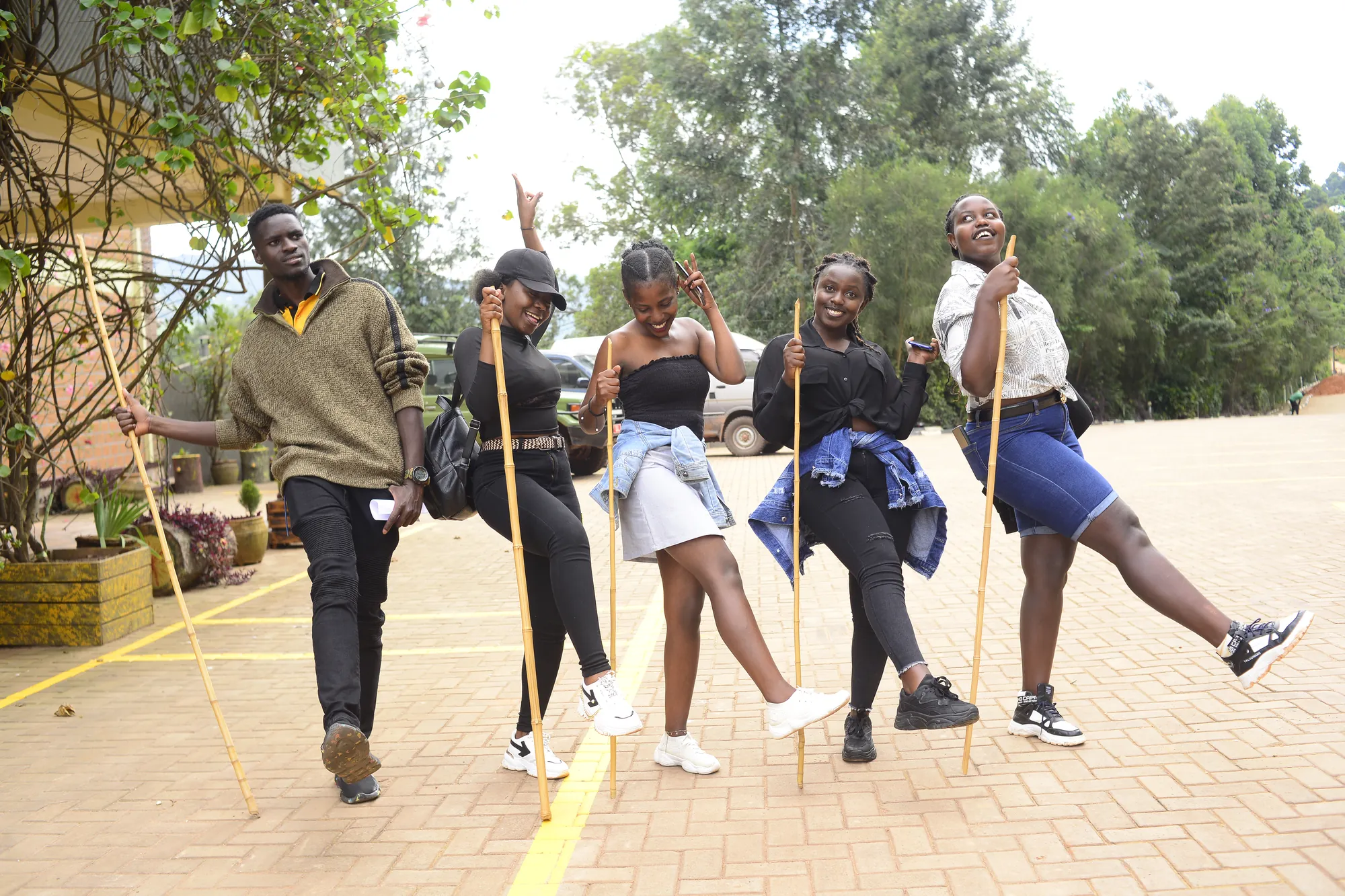 Five hikers posing with their sticks on the brick paving outside the resort before setting off