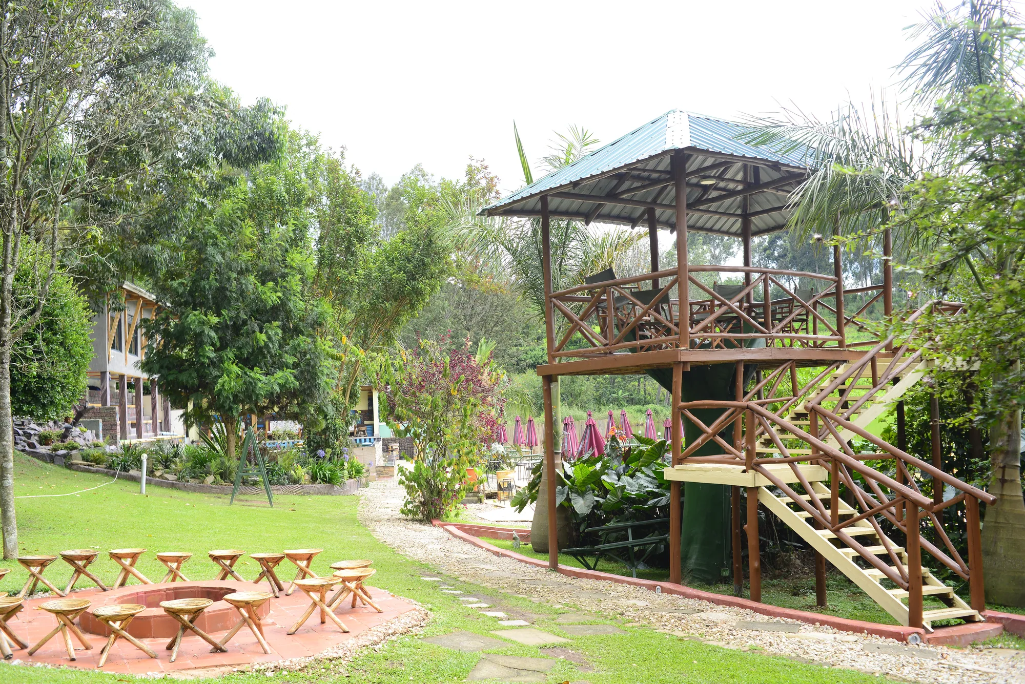 The tree-house tower seen across the lawn, with garden benches and the resort buildings behind