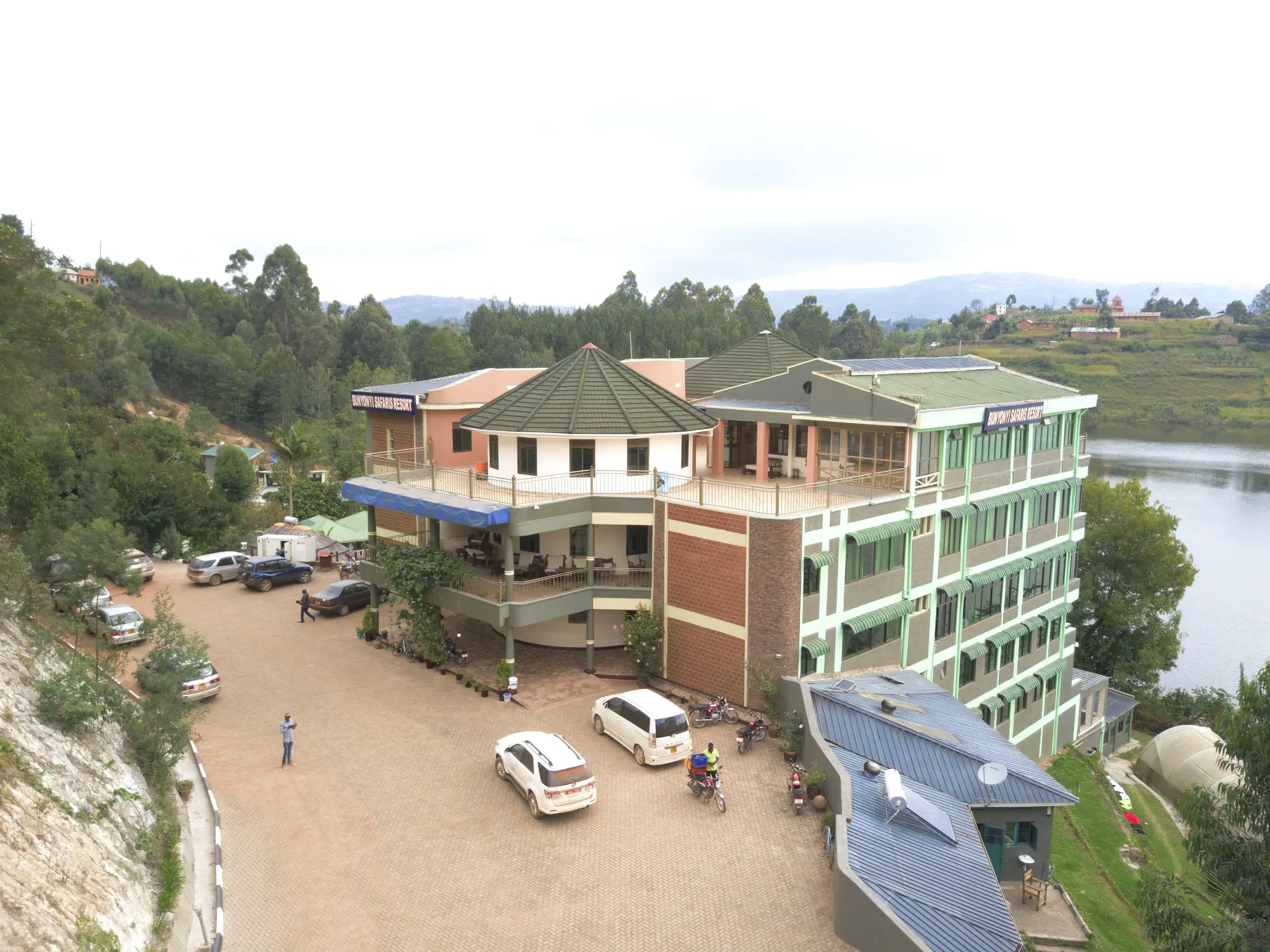 Aerial view of the hotel entrance side with cars parked on the forecourt and the lake beyond
