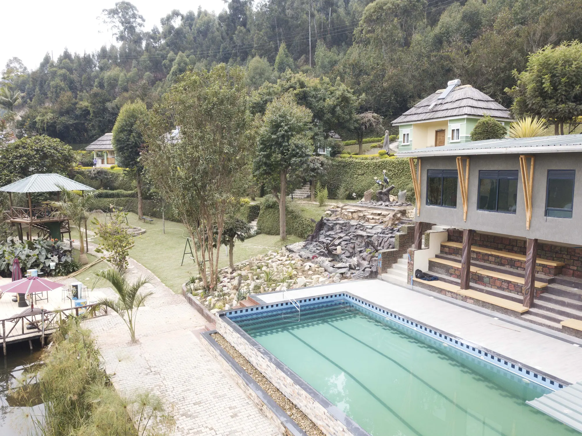 Aerial view of the pool terrace and the stone retaining wall below the hotel rooms