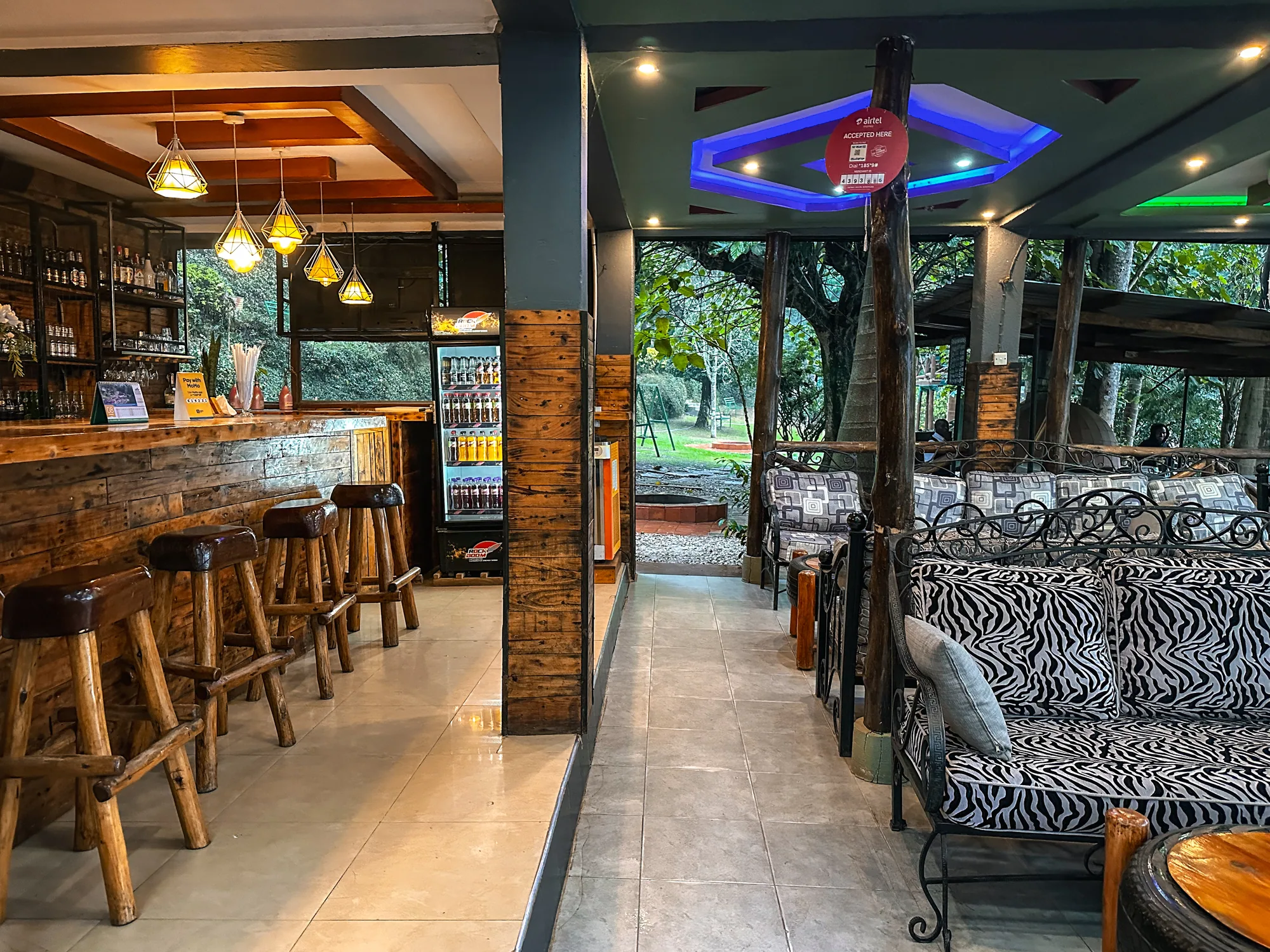 The bar counter with carved wooden stools, seen from the lounge doorway towards the garden