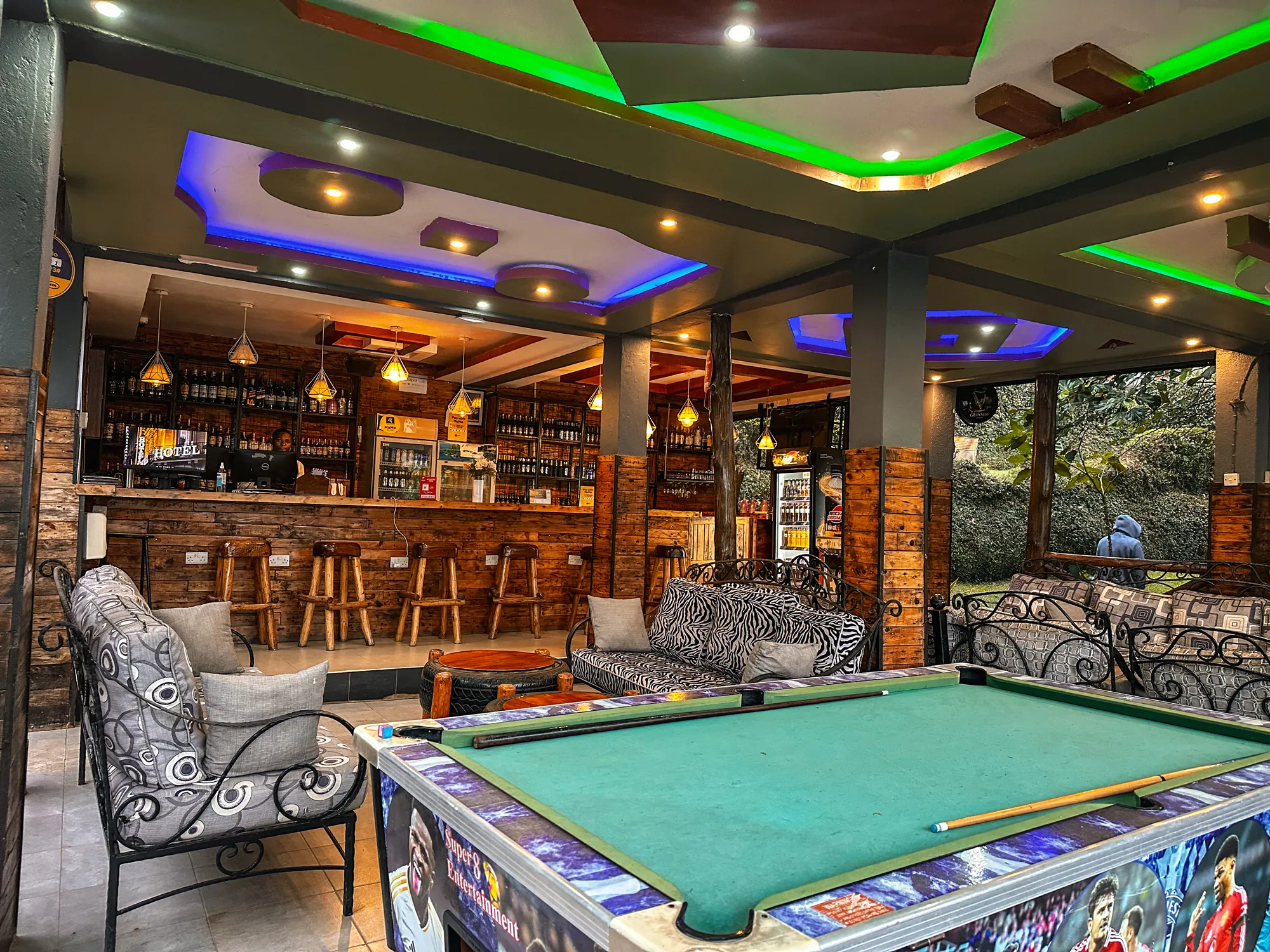 The pool table and bar counter in the games lounge, with windows onto the hillside
