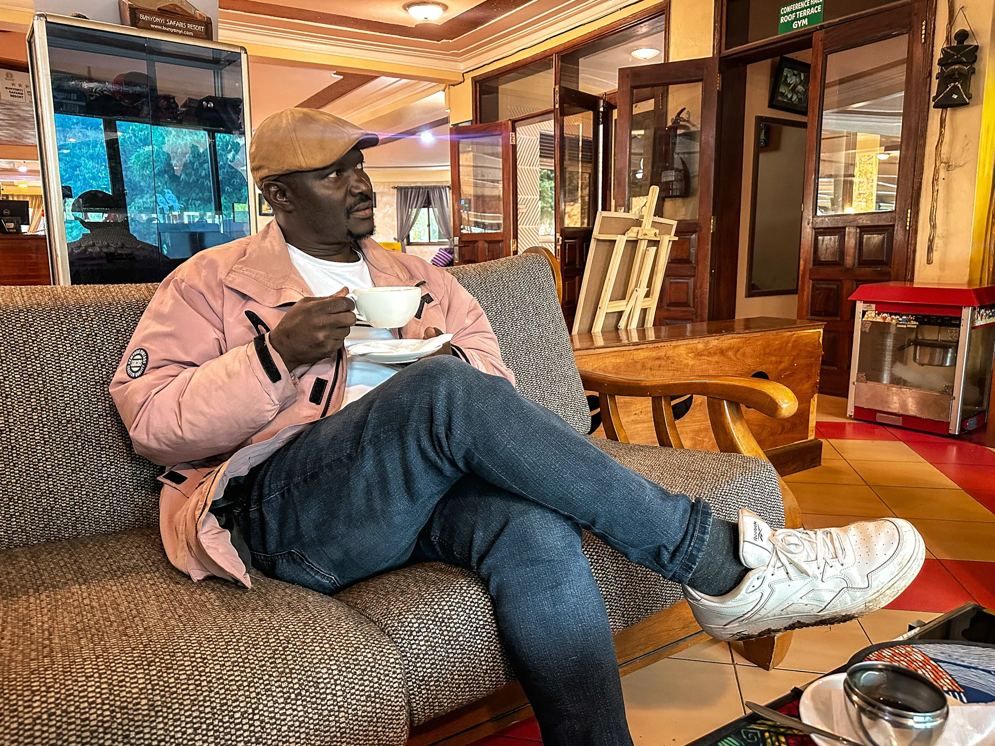 A guest sitting with a cup of coffee on a sofa in the timber-panelled lounge