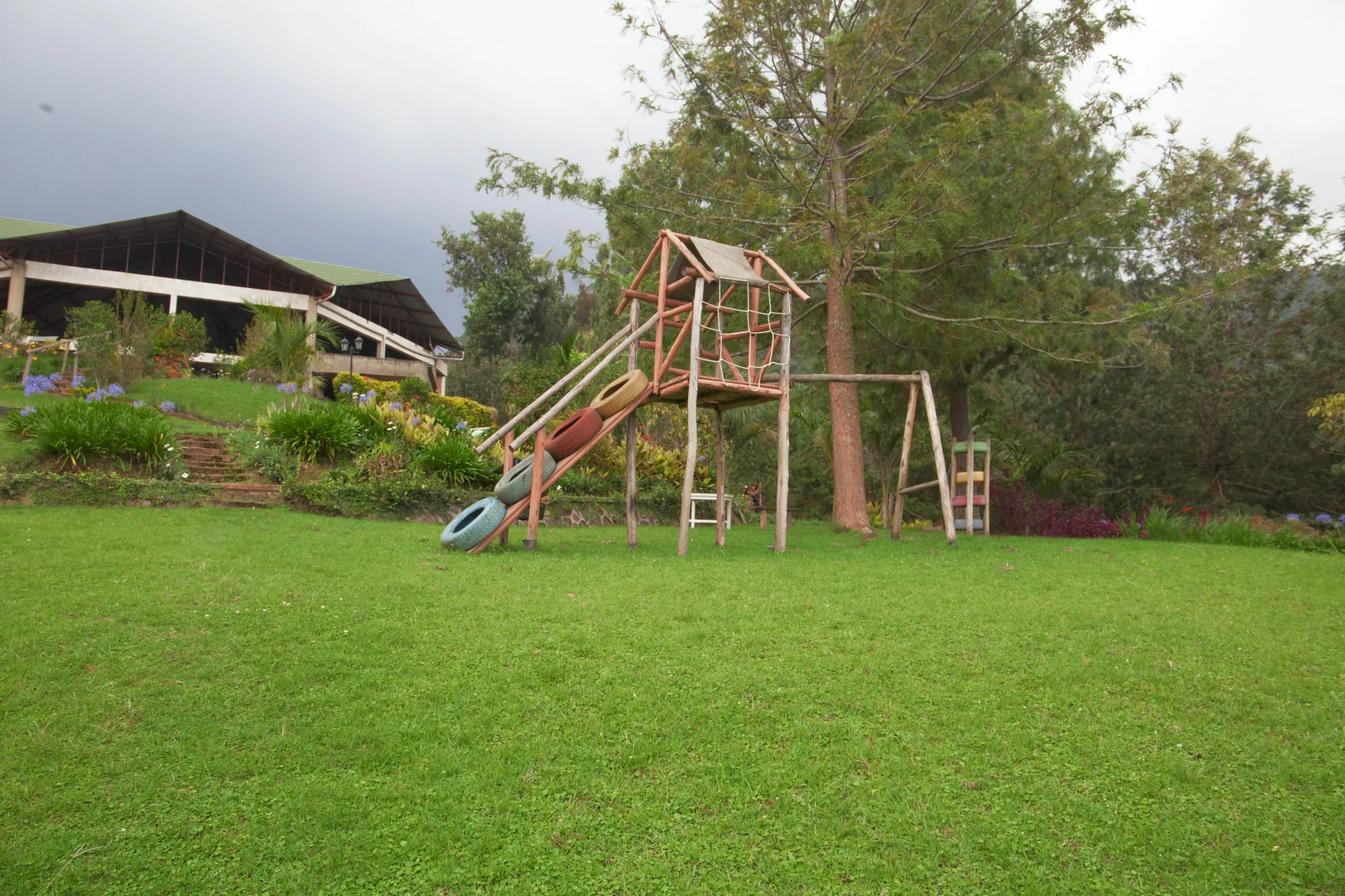 A timber climbing frame with a slide on the lawn of the children's play area