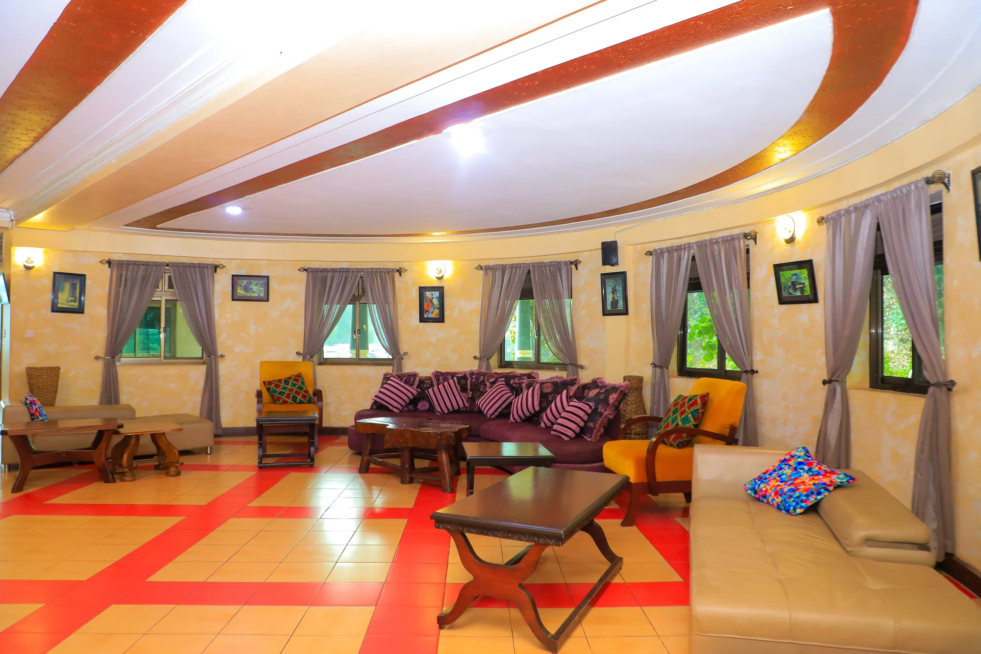 A large function lounge with cushioned bench seating, a curved white ceiling and red patterned floor