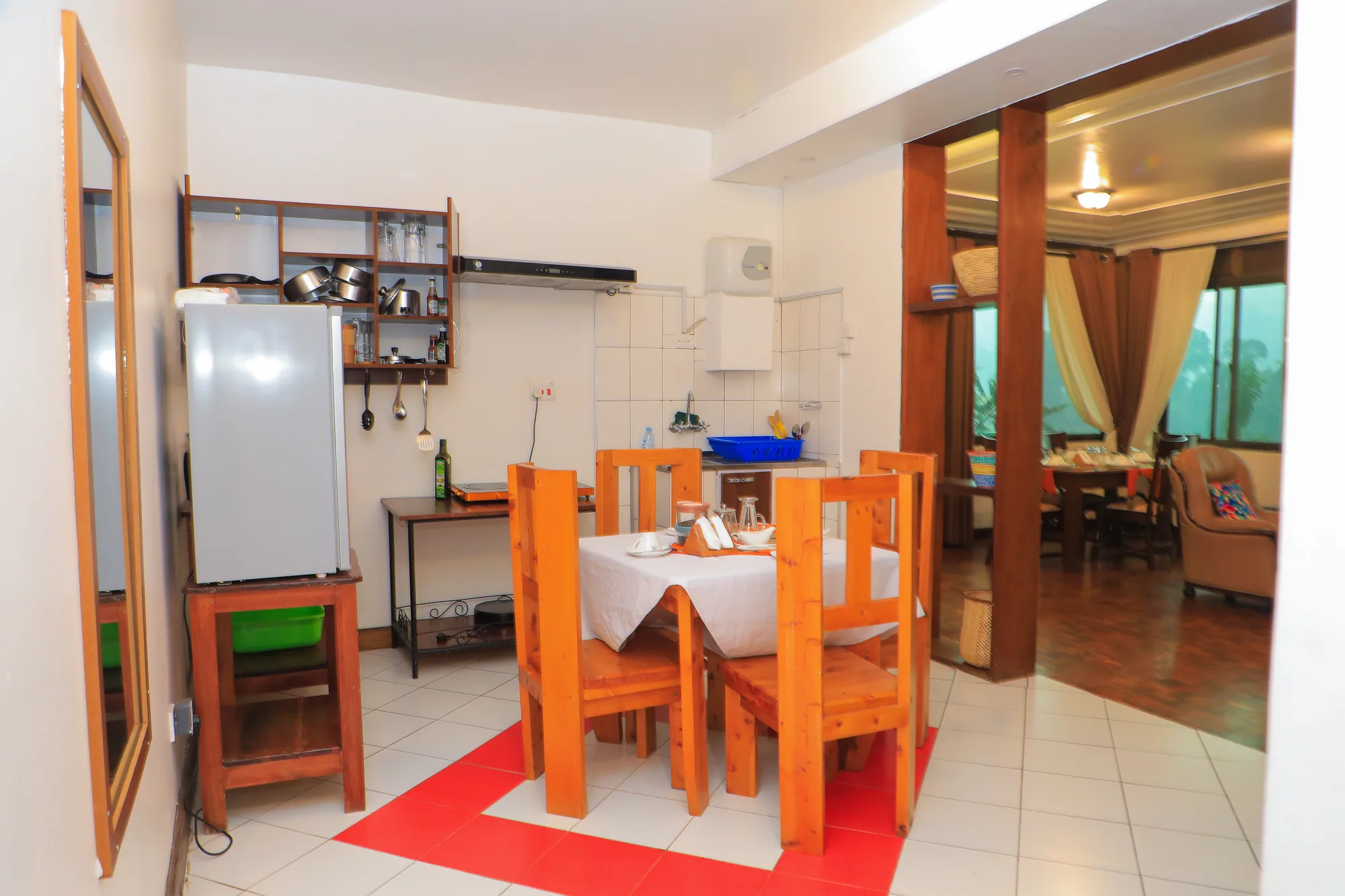 A kitchenette and dining table in a self-catering unit, with the sitting area beyond