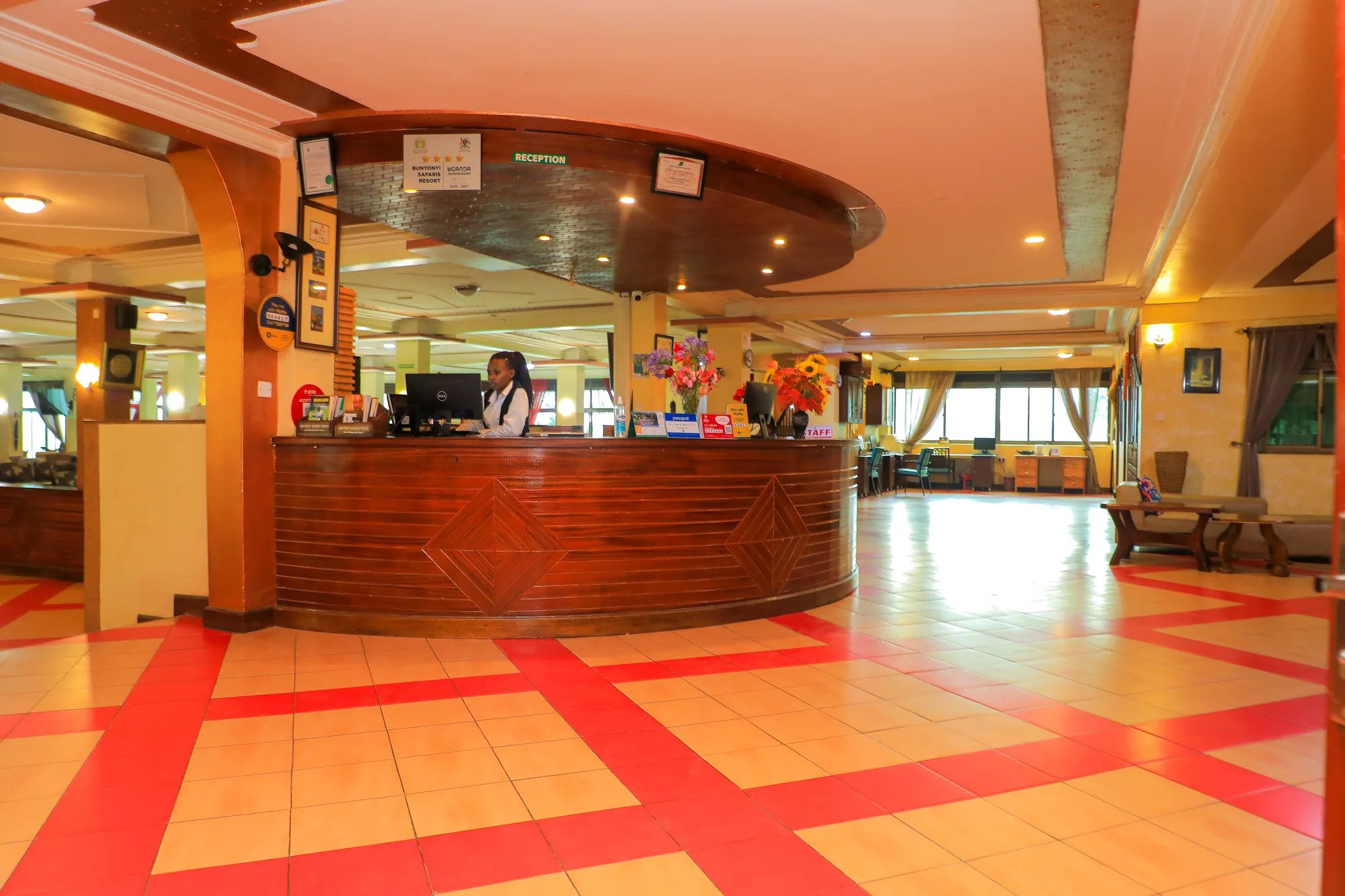 The reception hall with a curved polished timber desk and a red patterned tiled floor