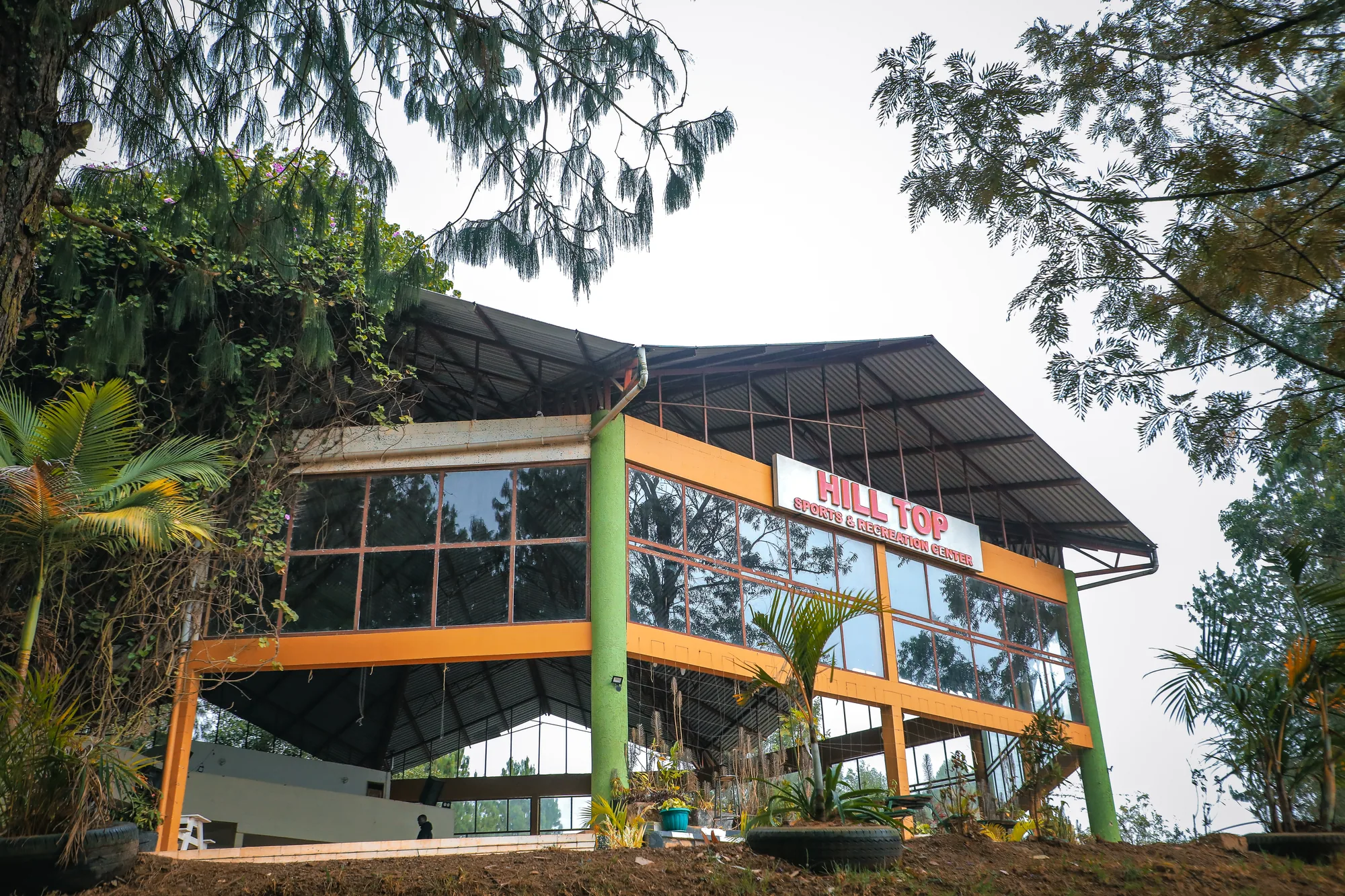 The Hill Top Events and Exhibition Centre seen from the side, its glass walls set in an orange frame