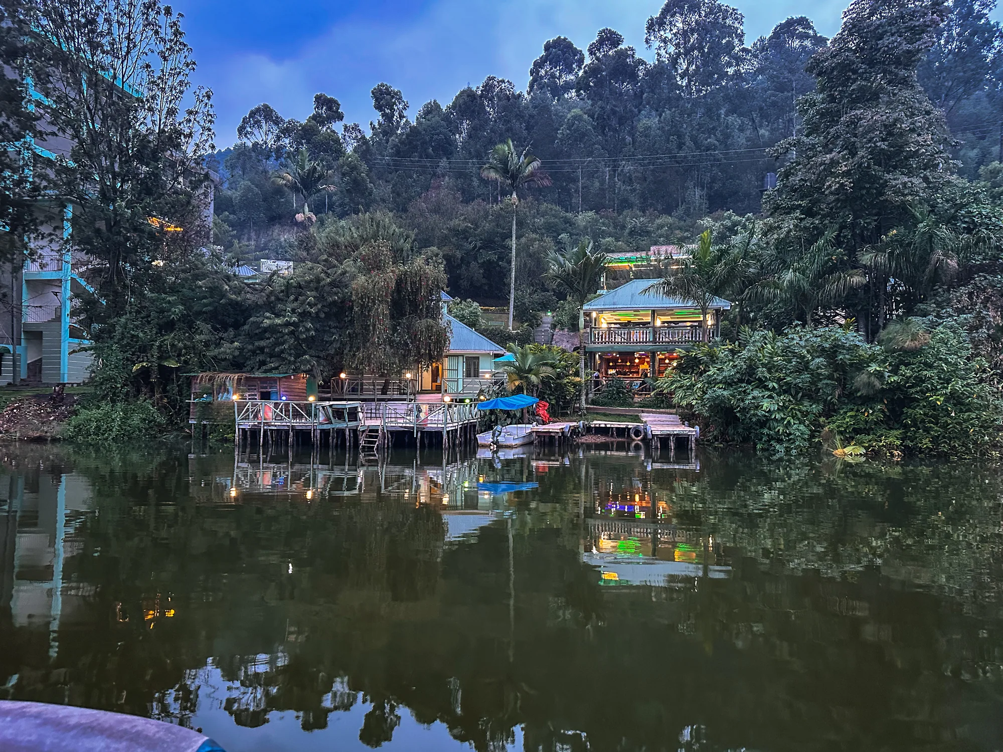 The resort buildings and lakeside decks reflected in the still water at dusk