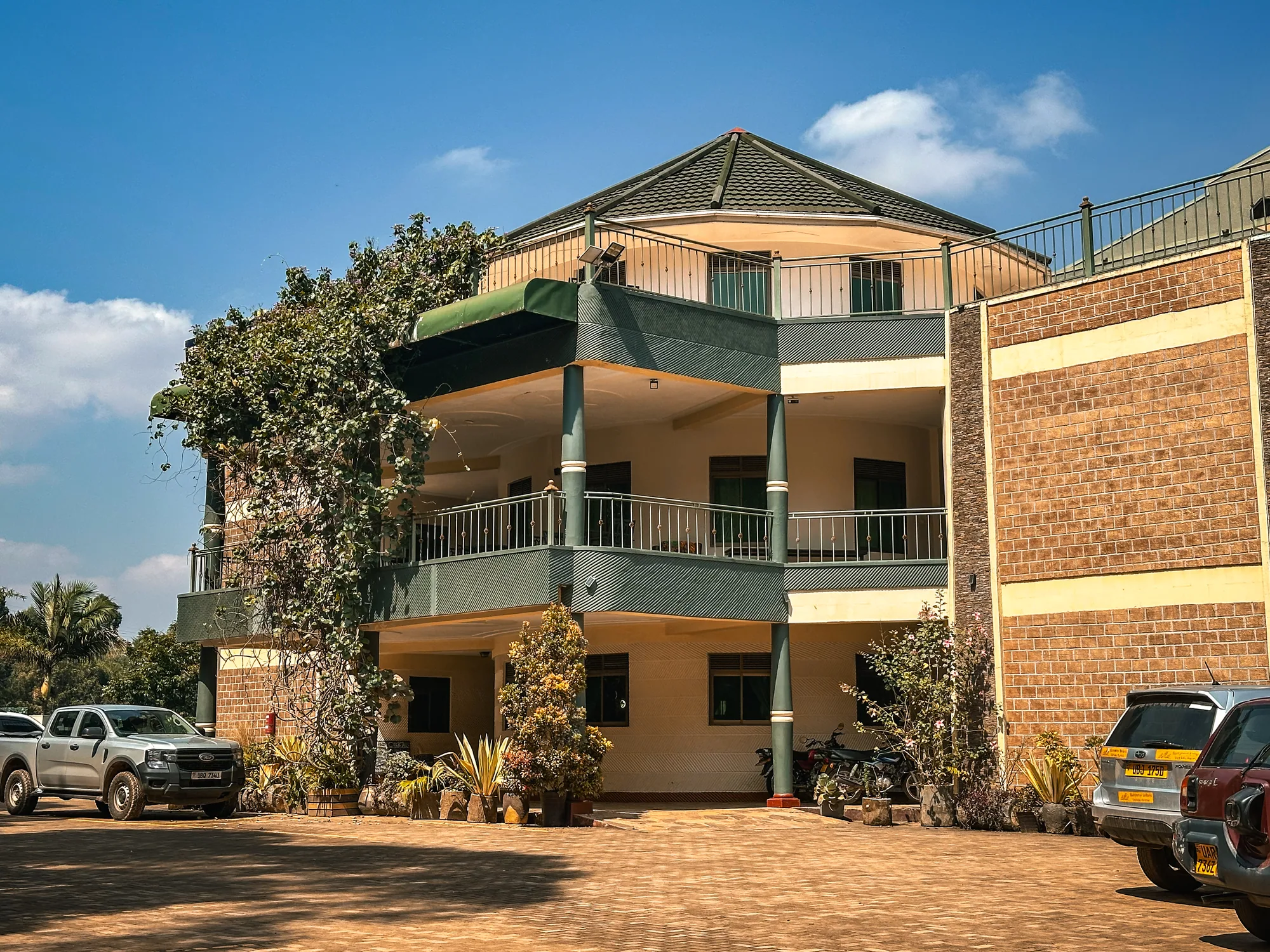 The cream and brick guest block with balconies and a pickup parked in front
