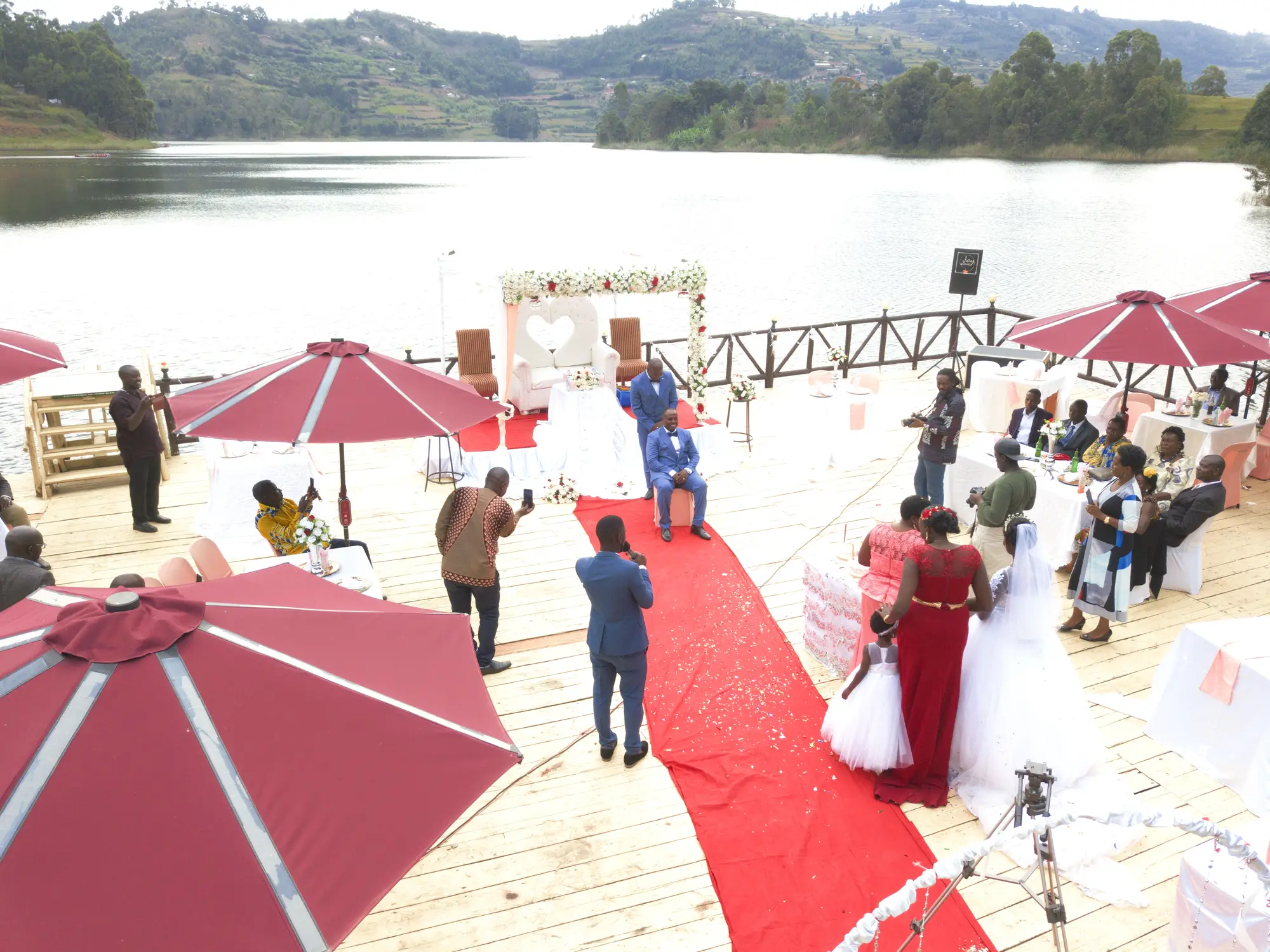 Wedding ceremony set up on the lakeside deck with a red carpet and burgundy parasols