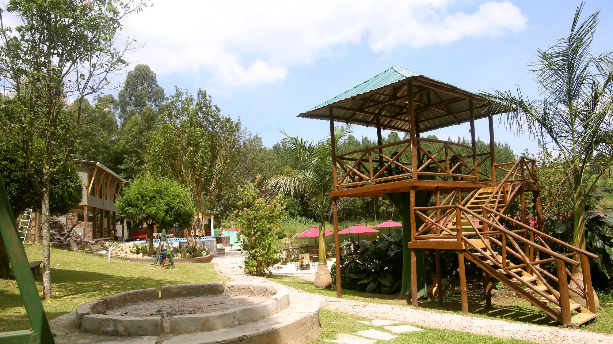 Garden with a wooden tree house and a stone fire pit