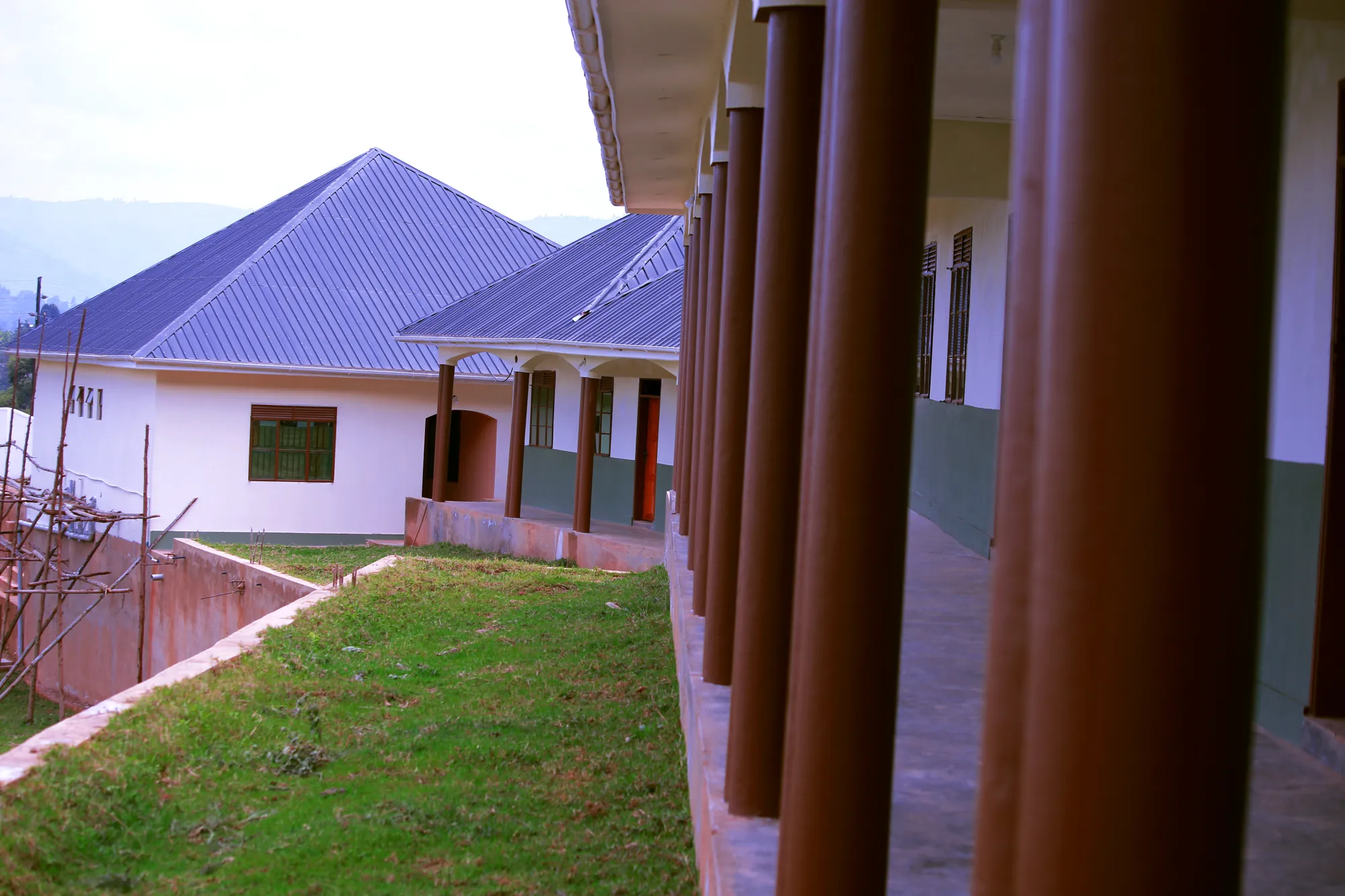 A classroom block with a purple-blue roof seen past the columns of the covered walkway