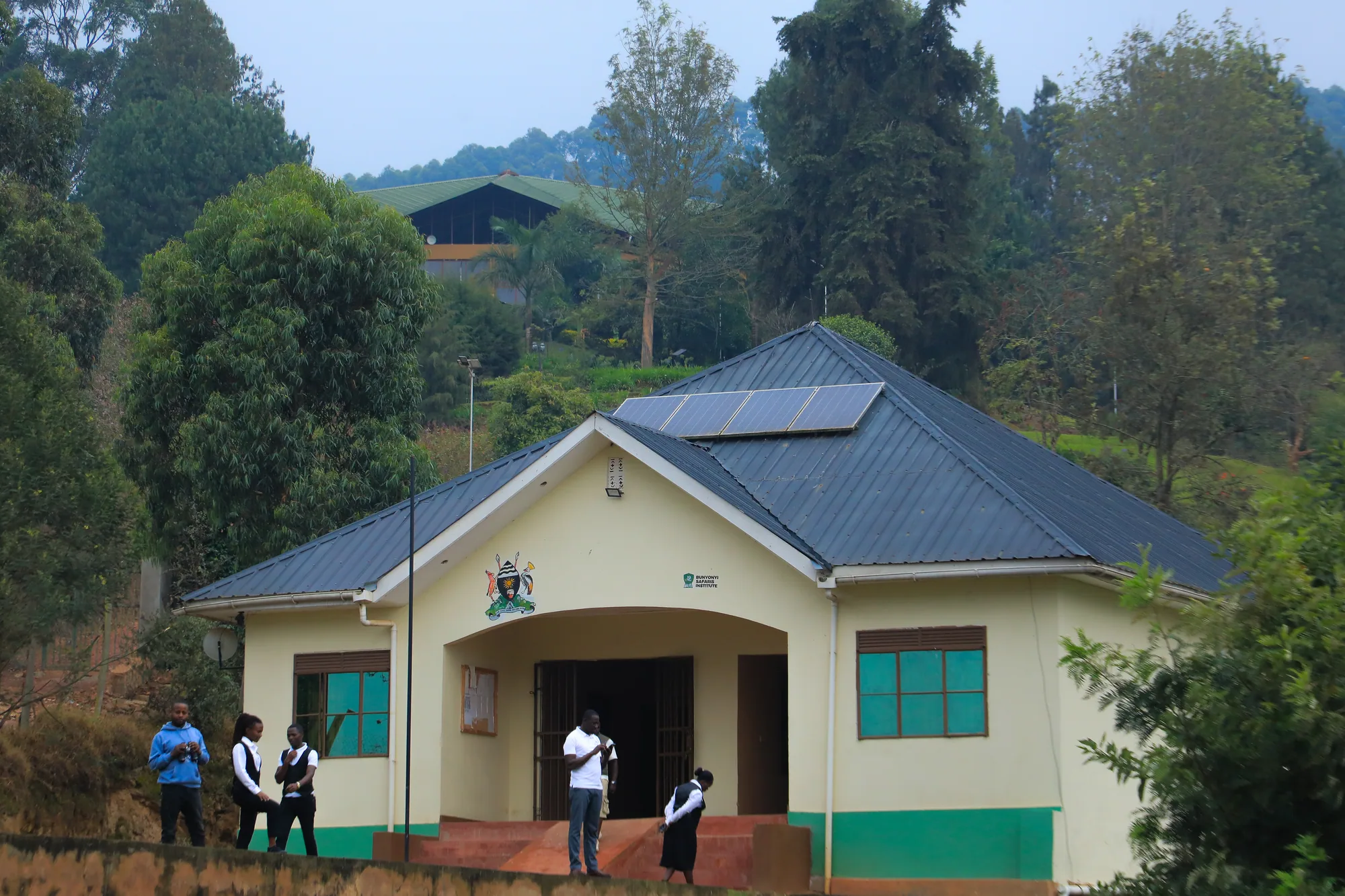 The institute main entrance building with its coat of arms above the door and students outside