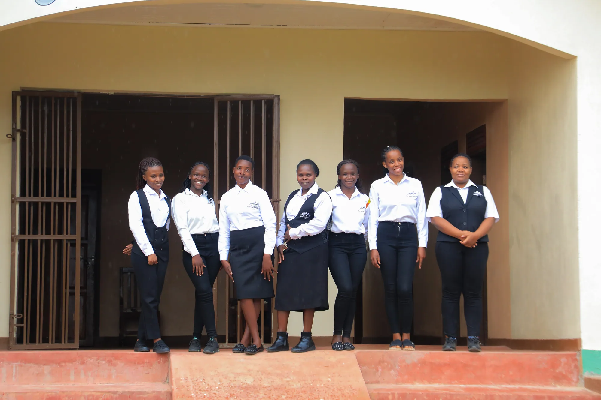 A line of students in uniform standing in a doorway of the institute