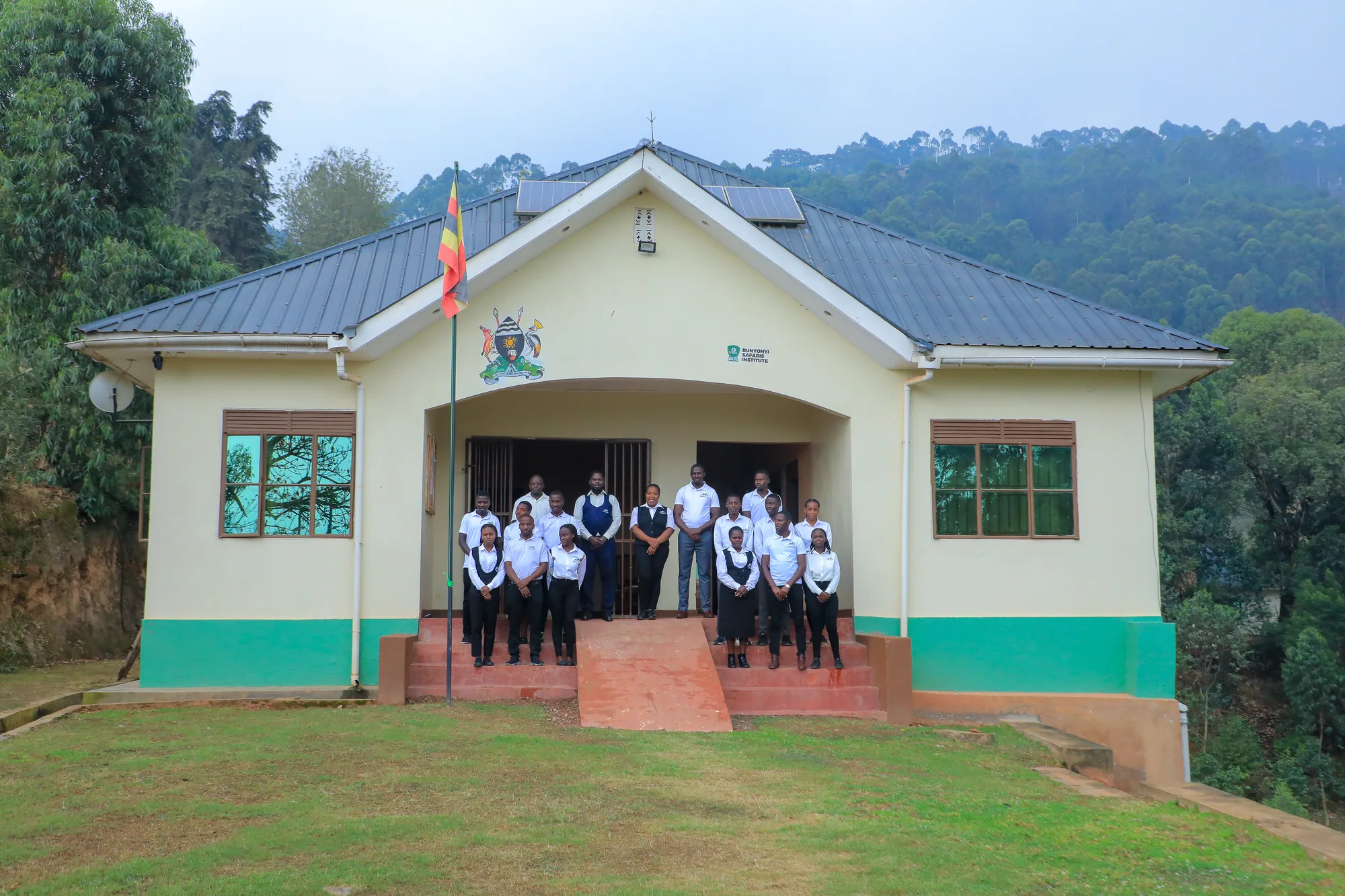 Students grouped on the entrance steps of the institute beside the national flag