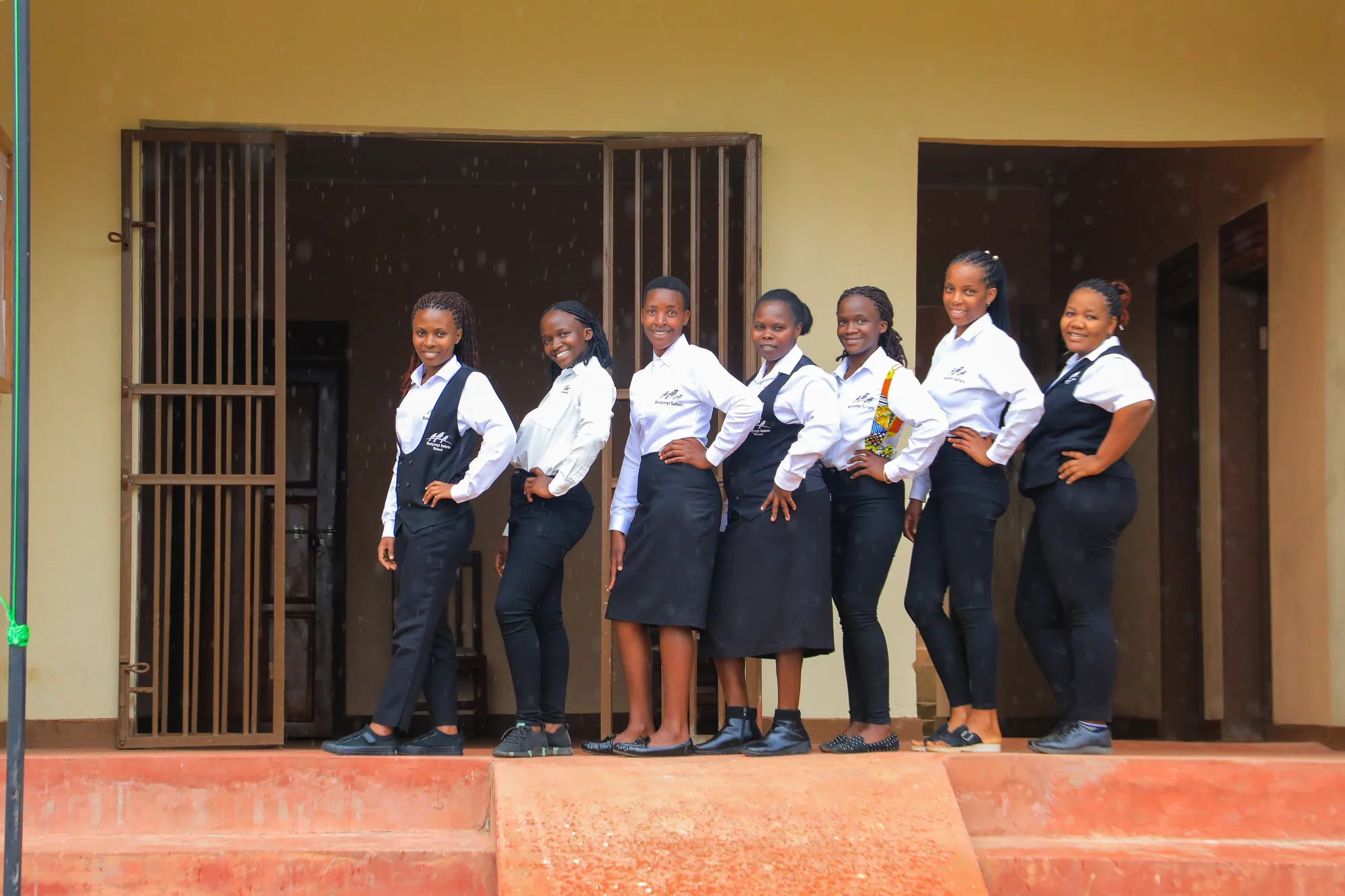 Students in uniform lined up along the wall beside the institute entrance