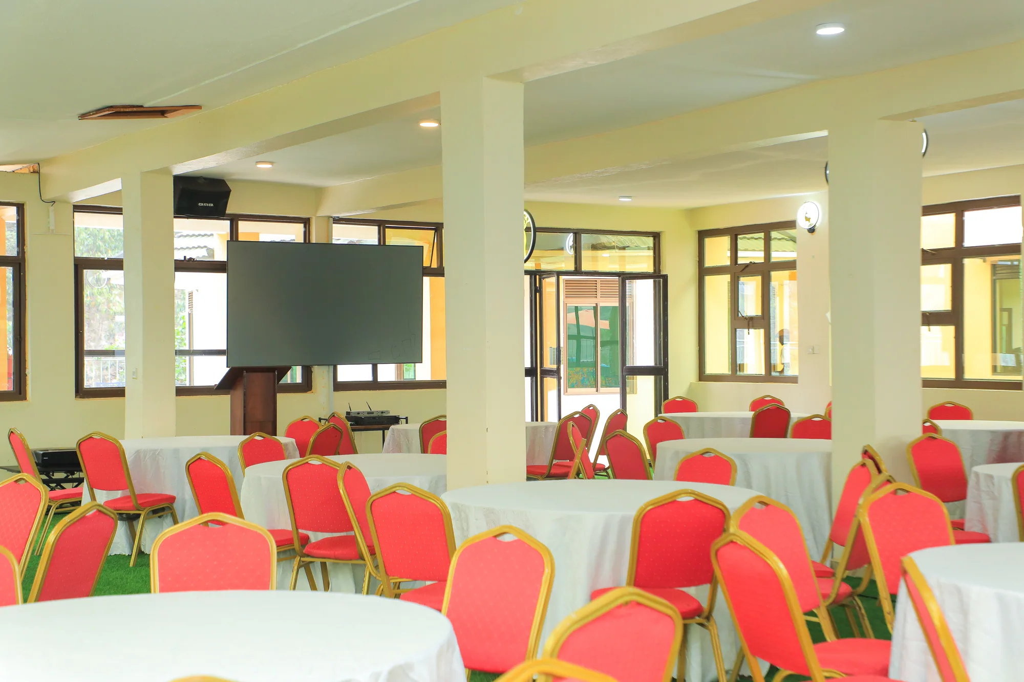 The banqueting hall from the far end, tables laid and a large screen on the wall