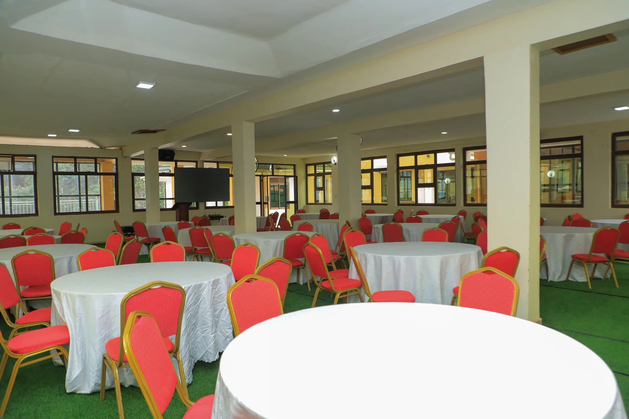 Round tables and red chairs filling the events hall, columns along the side
