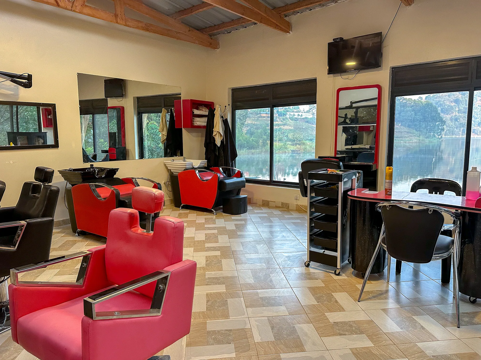 The salon interior with red styling chairs, mirrored stations and windows onto the lake