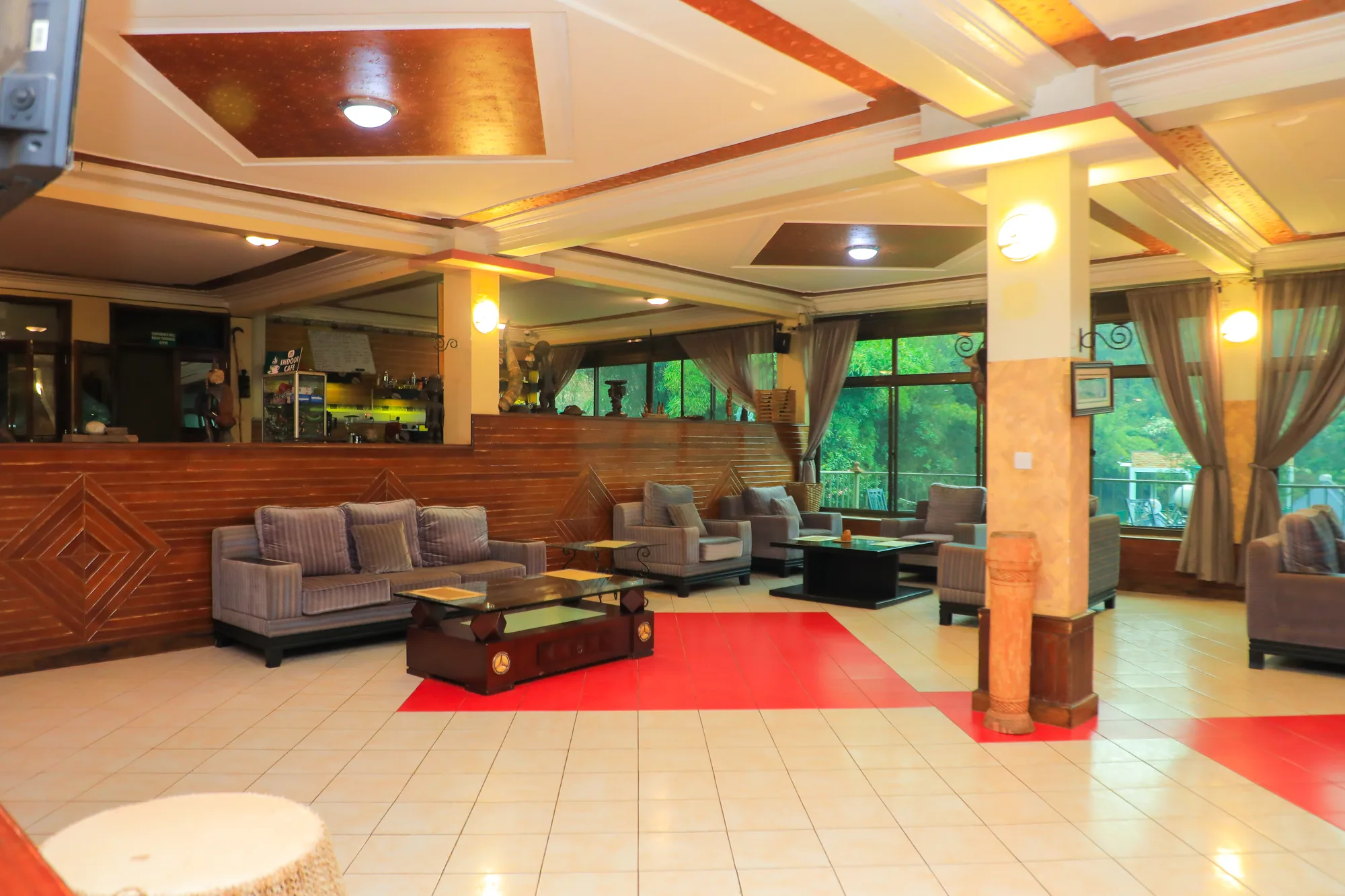 A lobby lounge with grey sofa suites, columns and a red patterned floor
