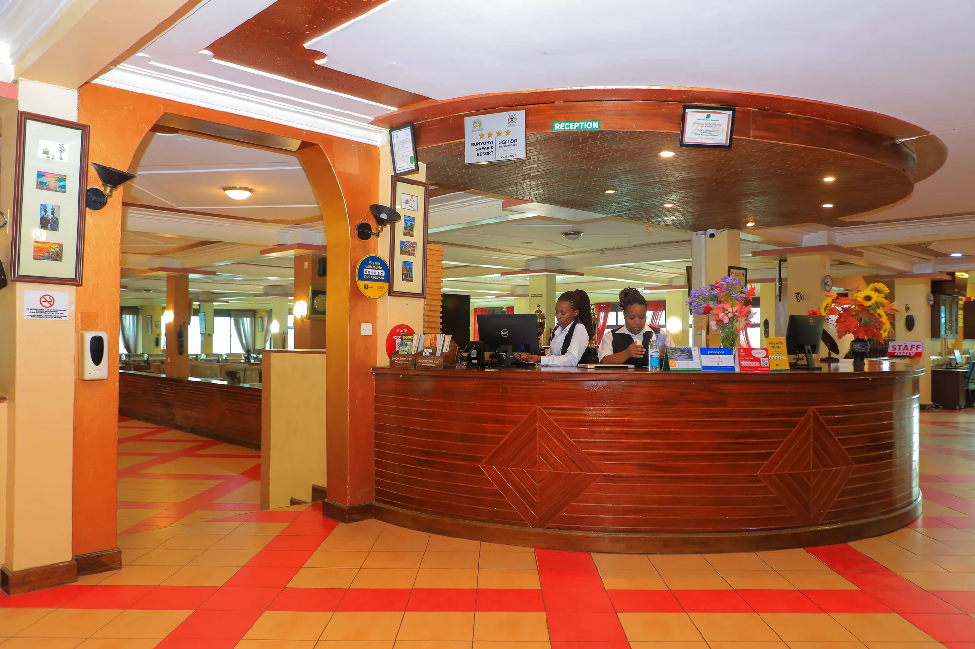 The curved timber reception desk with staff behind it and notices on the columns