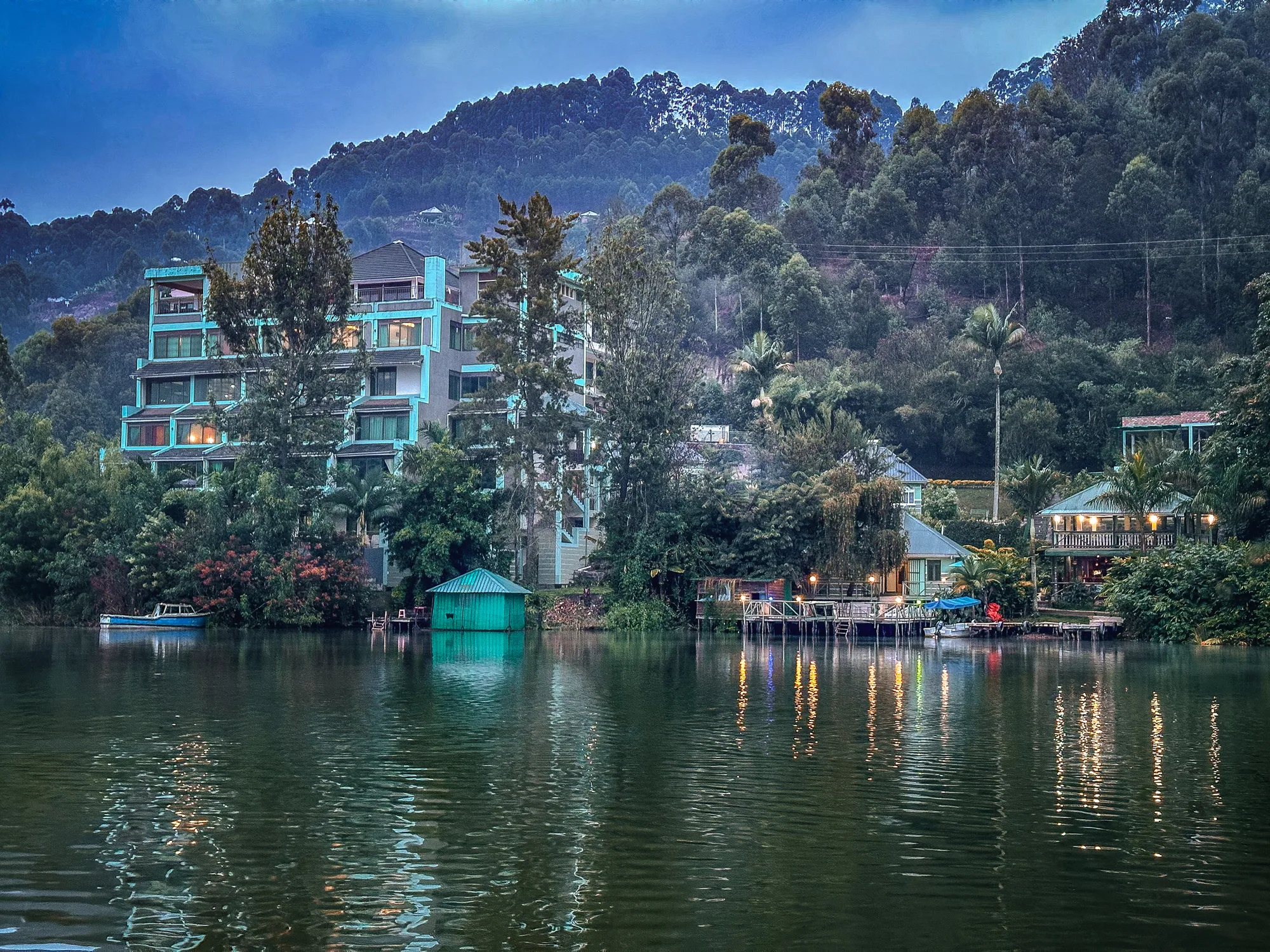 The resort buildings and lit decks along the shoreline at dusk