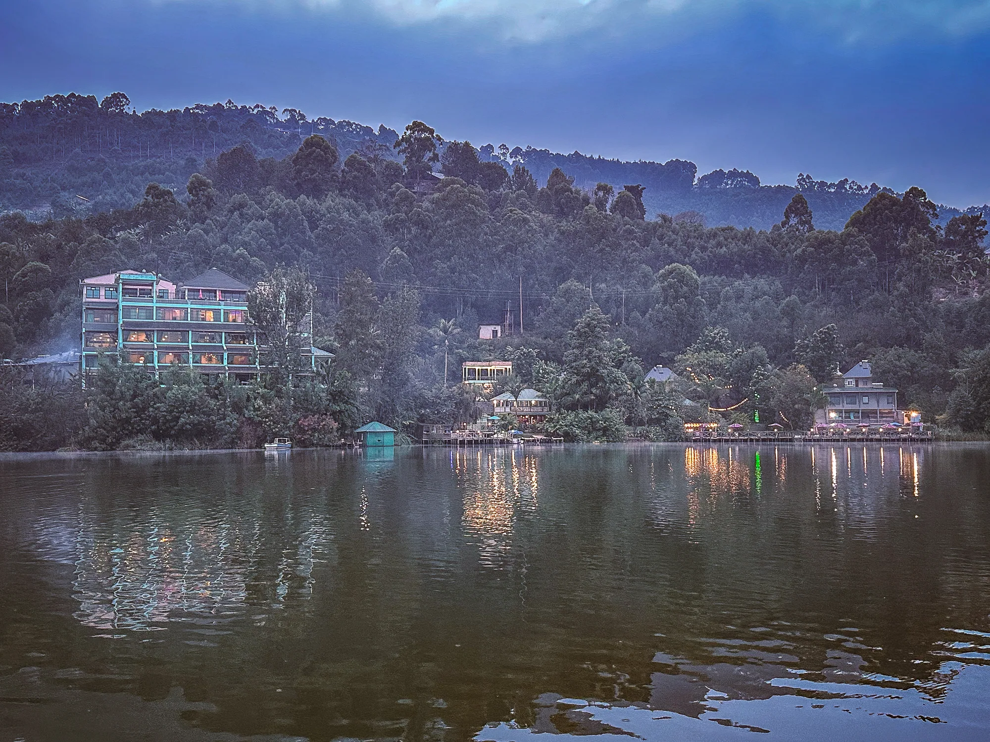The hotel block and shoreline reflected in the still lake at dawn