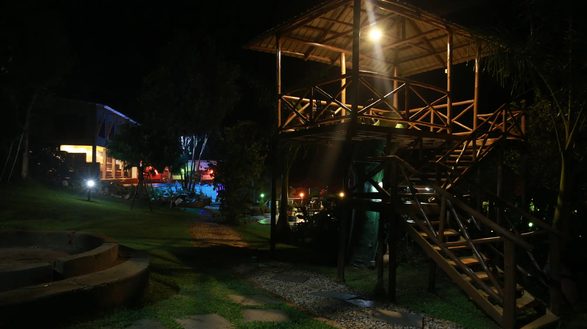 Wooden tree house lit at night in the garden