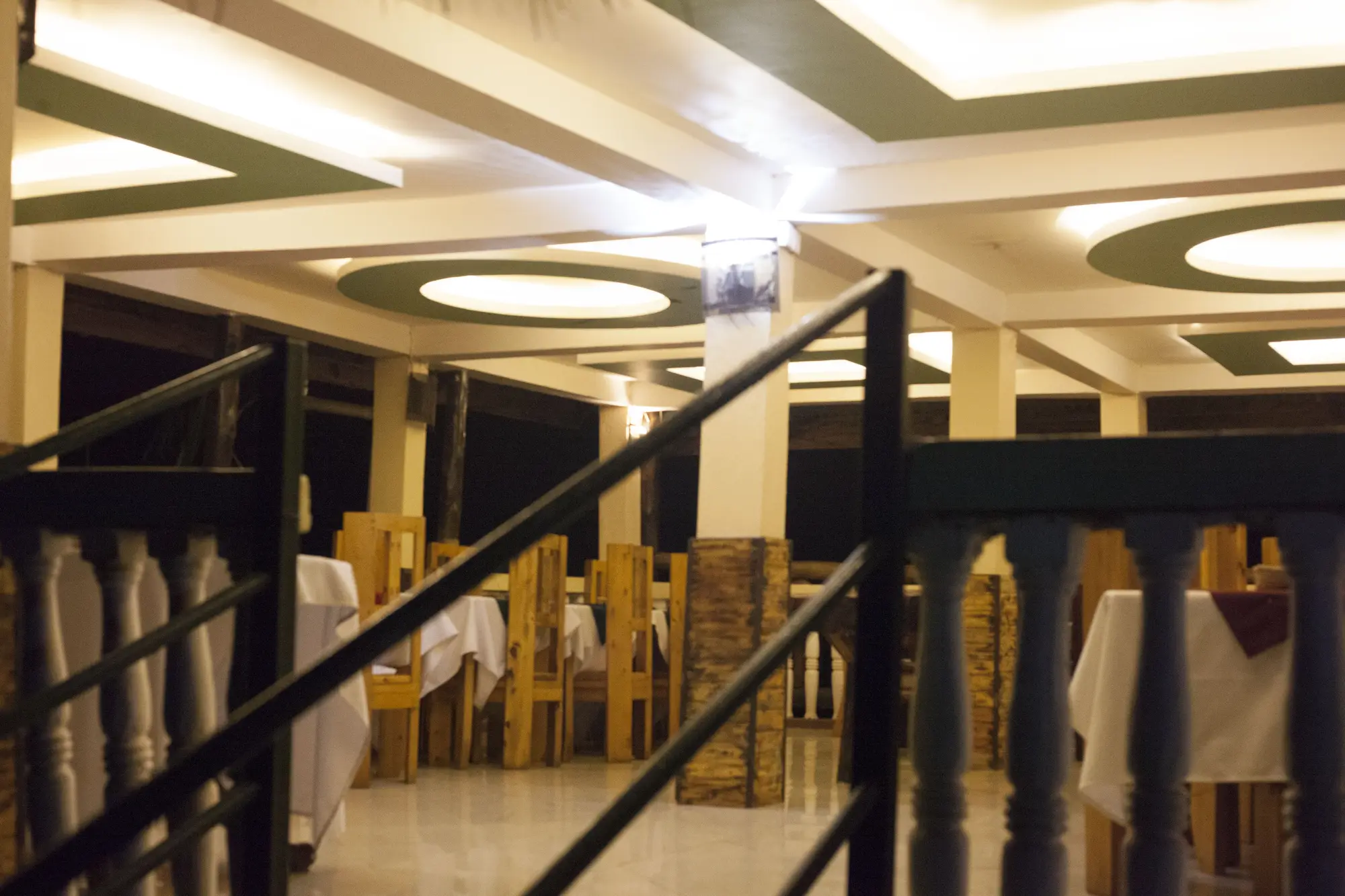 Restaurant dining room with white-clothed tables and wooden chairs