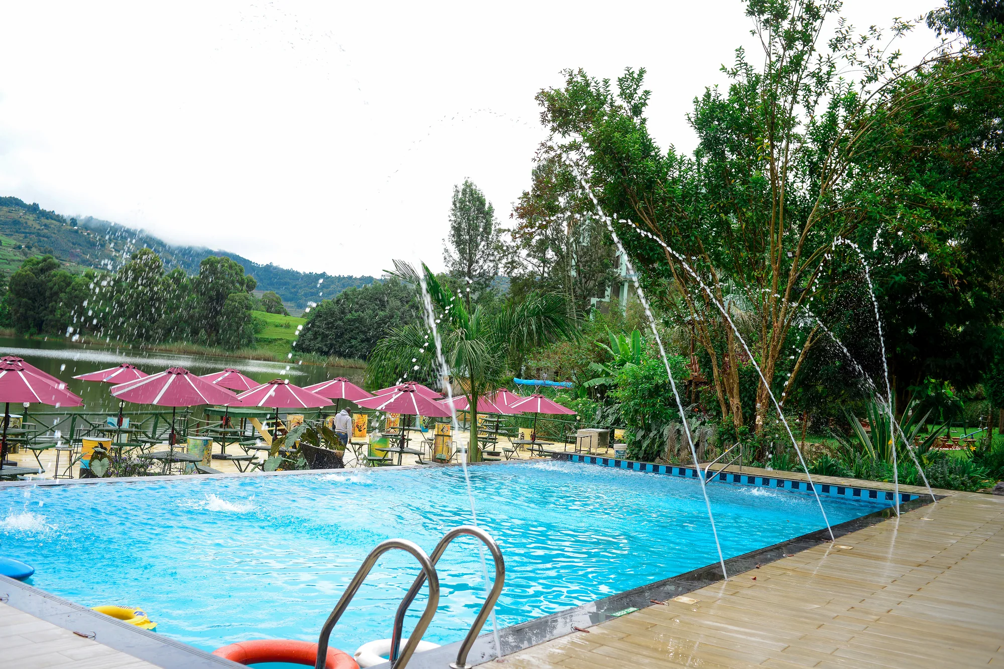 The pool with its water jets playing, pink parasols and loungers alongside