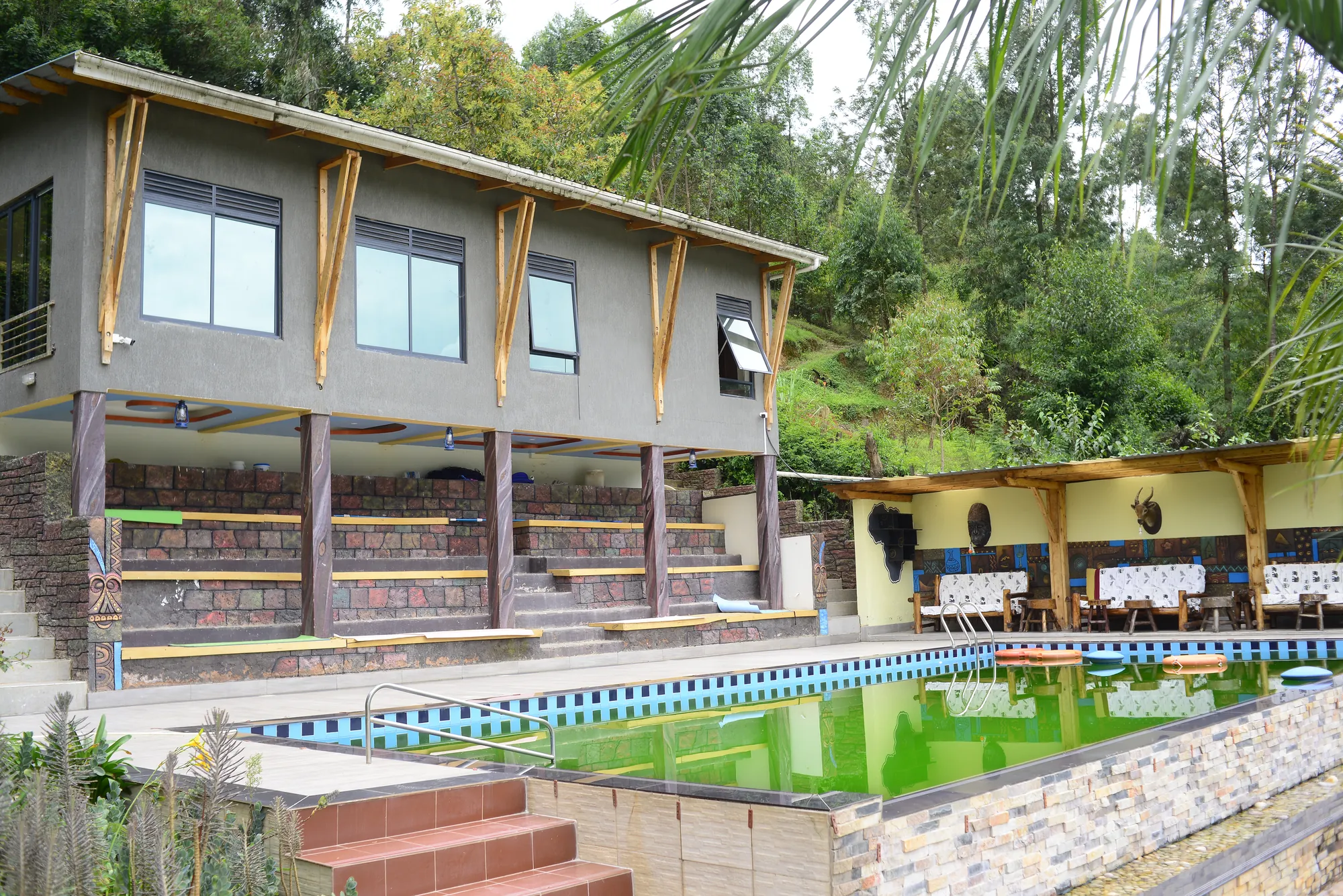 The pool in front of the timber-clad building, the water green before cleaning