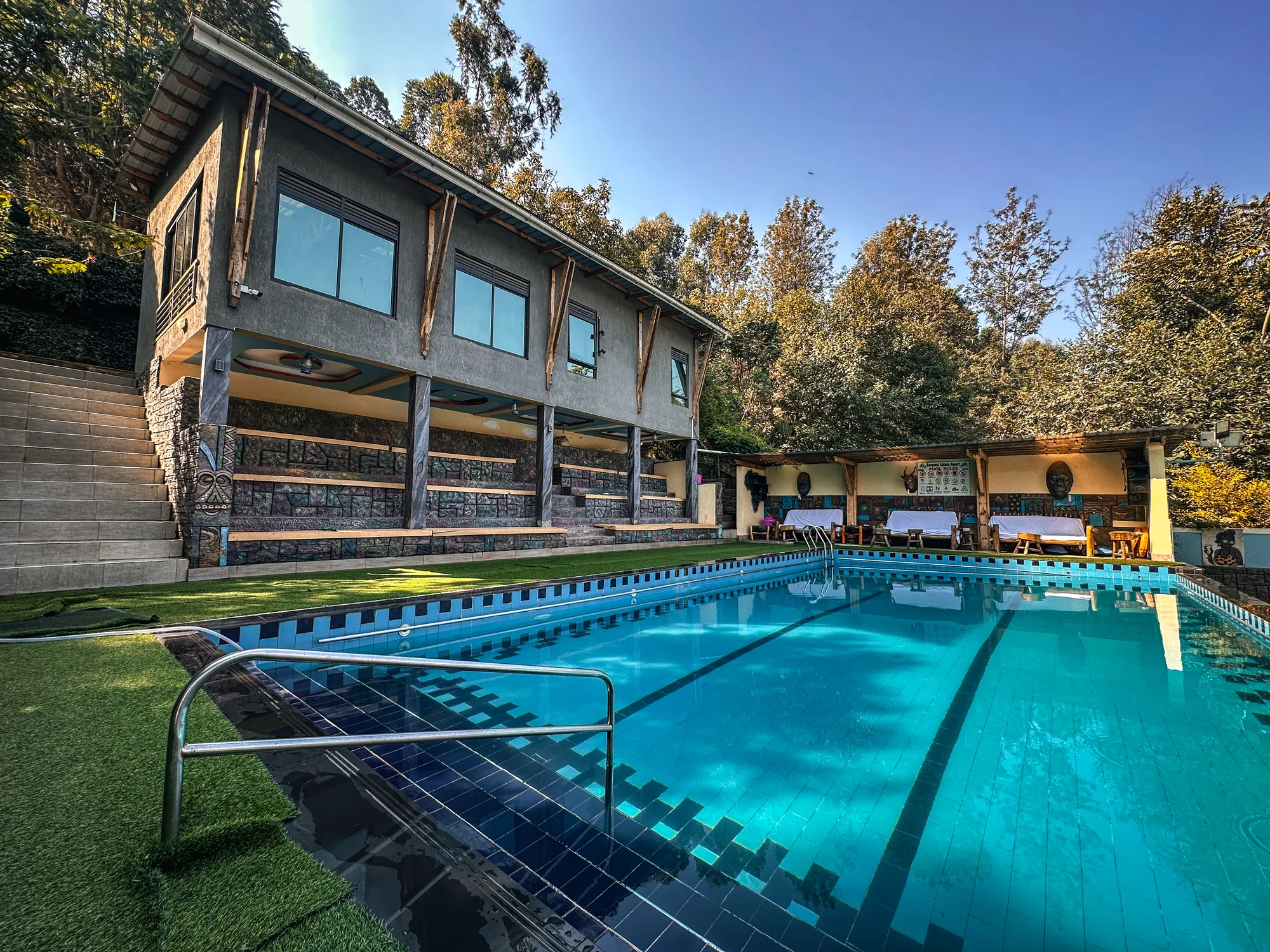 The pool from the shallow end, ladder in the foreground and rooms above