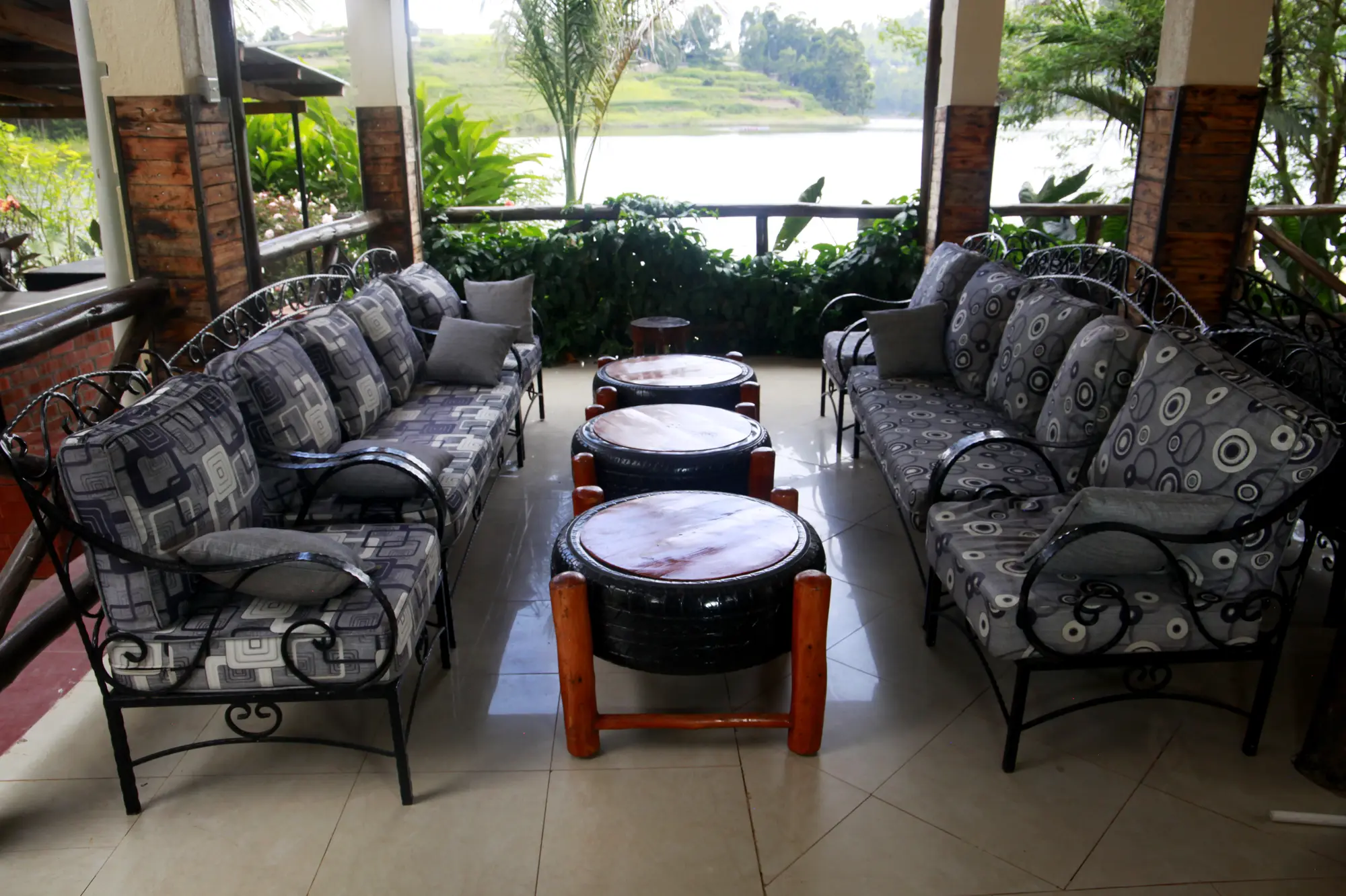 Lake-facing lounge with cushioned wrought-iron sofas and drum-style coffee tables