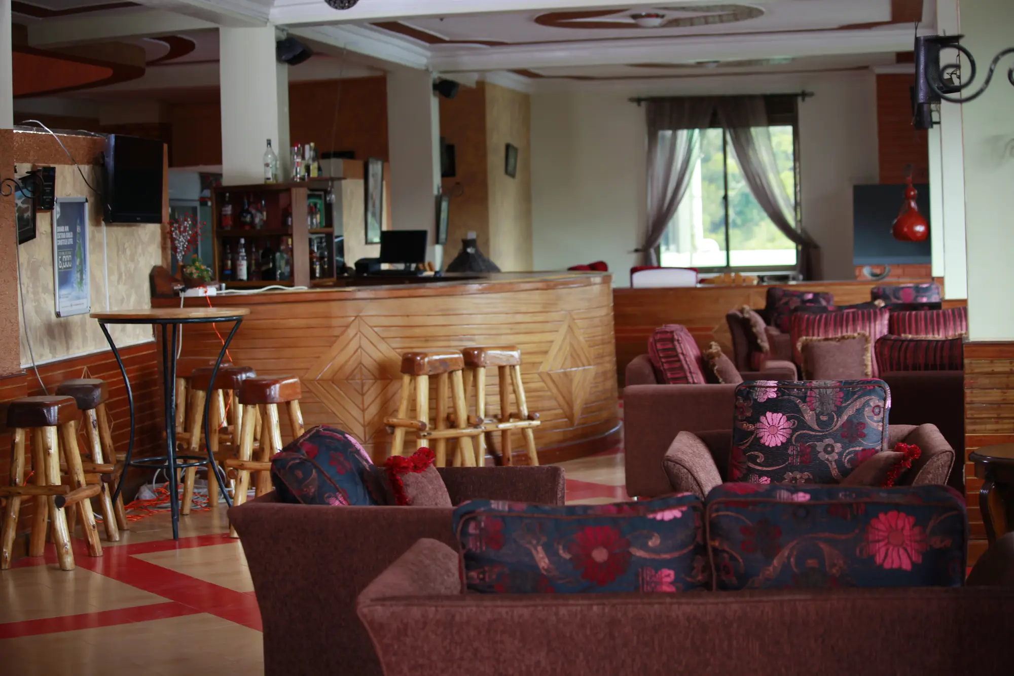 Indoor bar with a wooden counter, stools and lounge sofas
