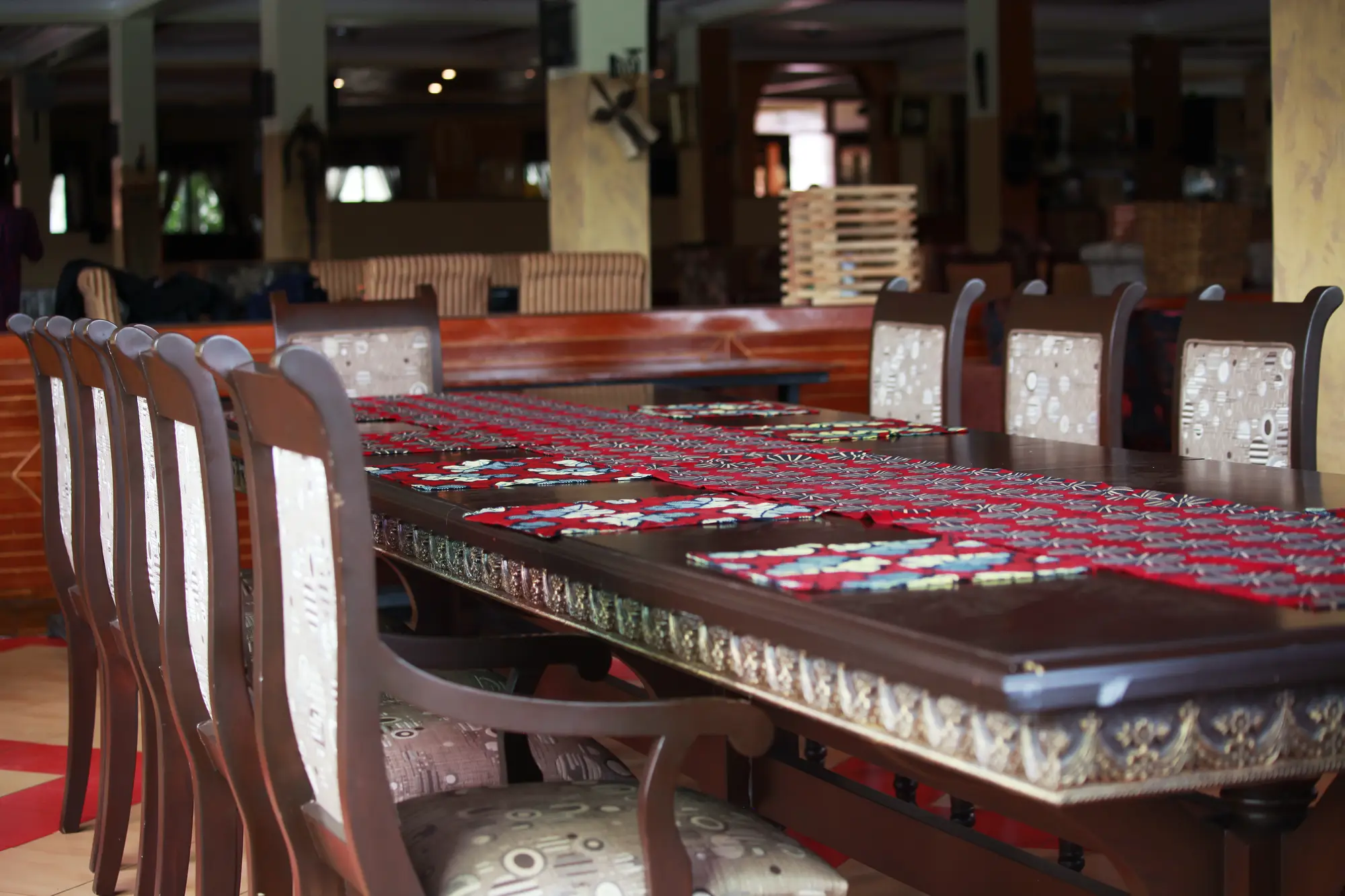 Long polished table with high-backed chairs set up for a meeting