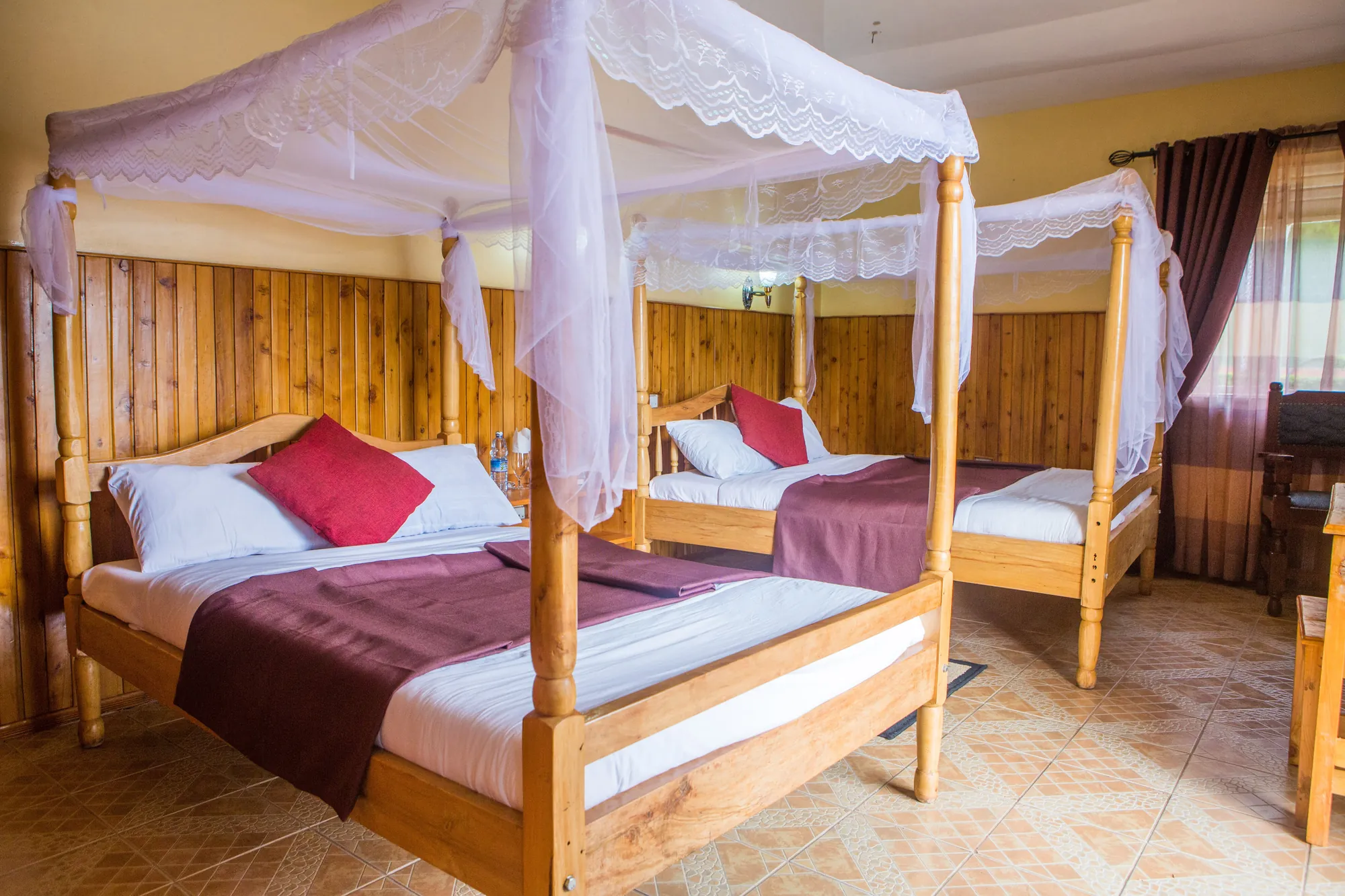 Double / Twin Room with two four-poster beds, mosquito nets and maroon throws