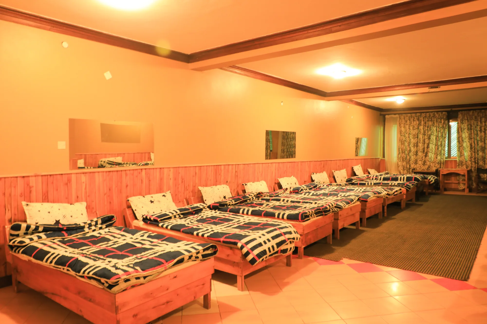 Dormitory: dormitory room with beds in rows against orange walls and timber panelling