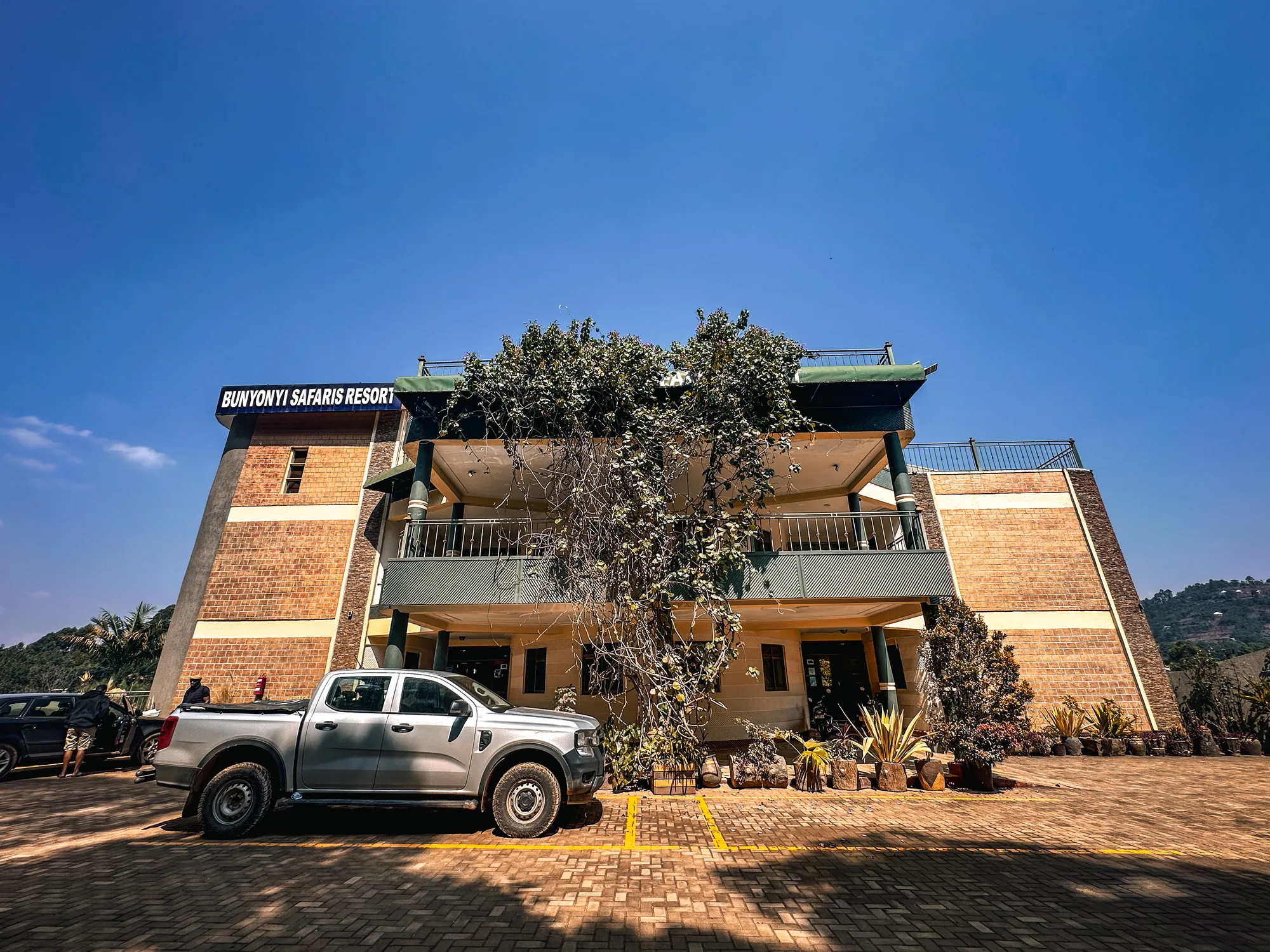 The signed resort building frontage in bright sun with a pickup parked outside
