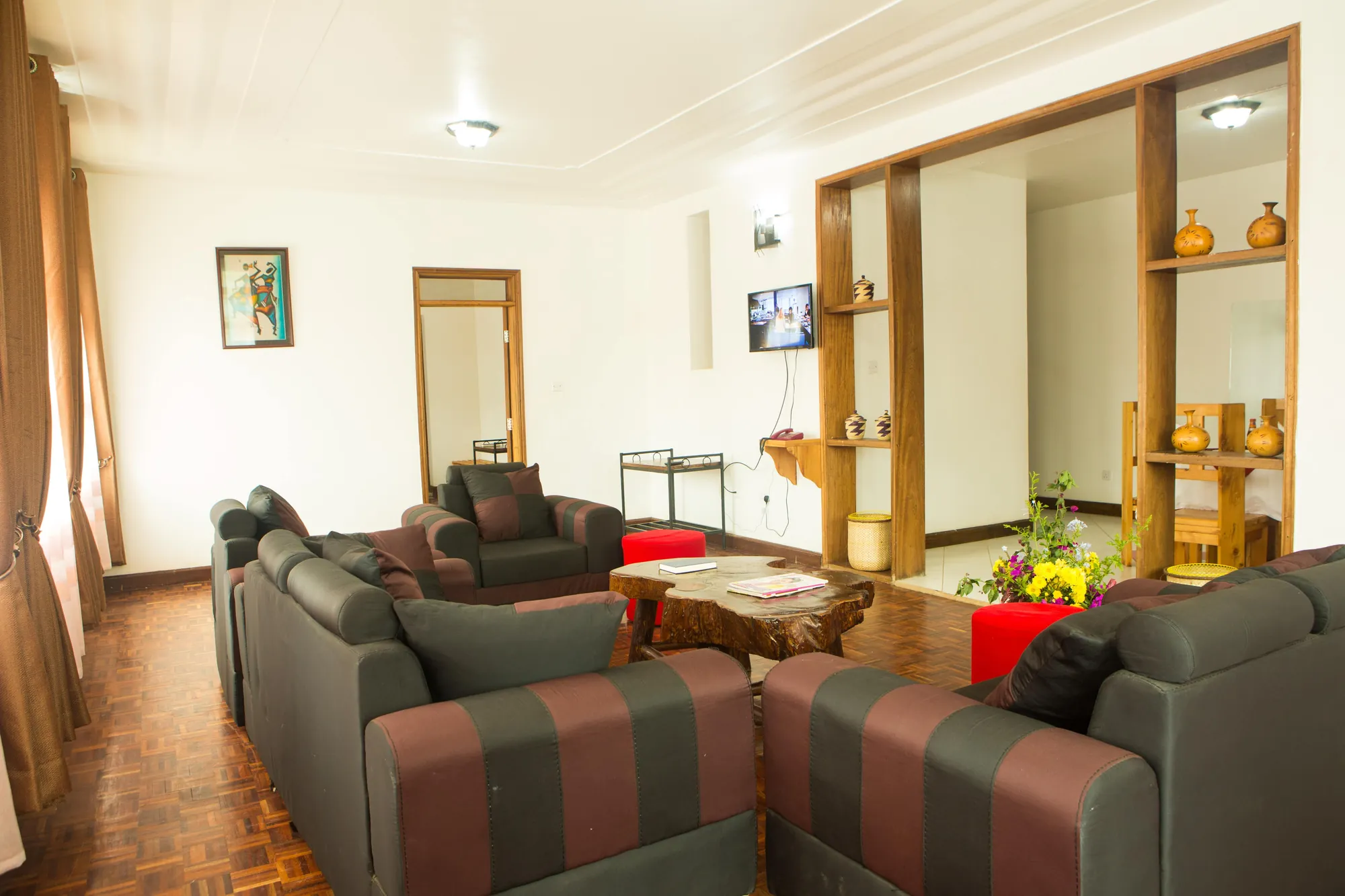 Family Suite: suite sitting room with grey and maroon sofas and a timber shelf divider