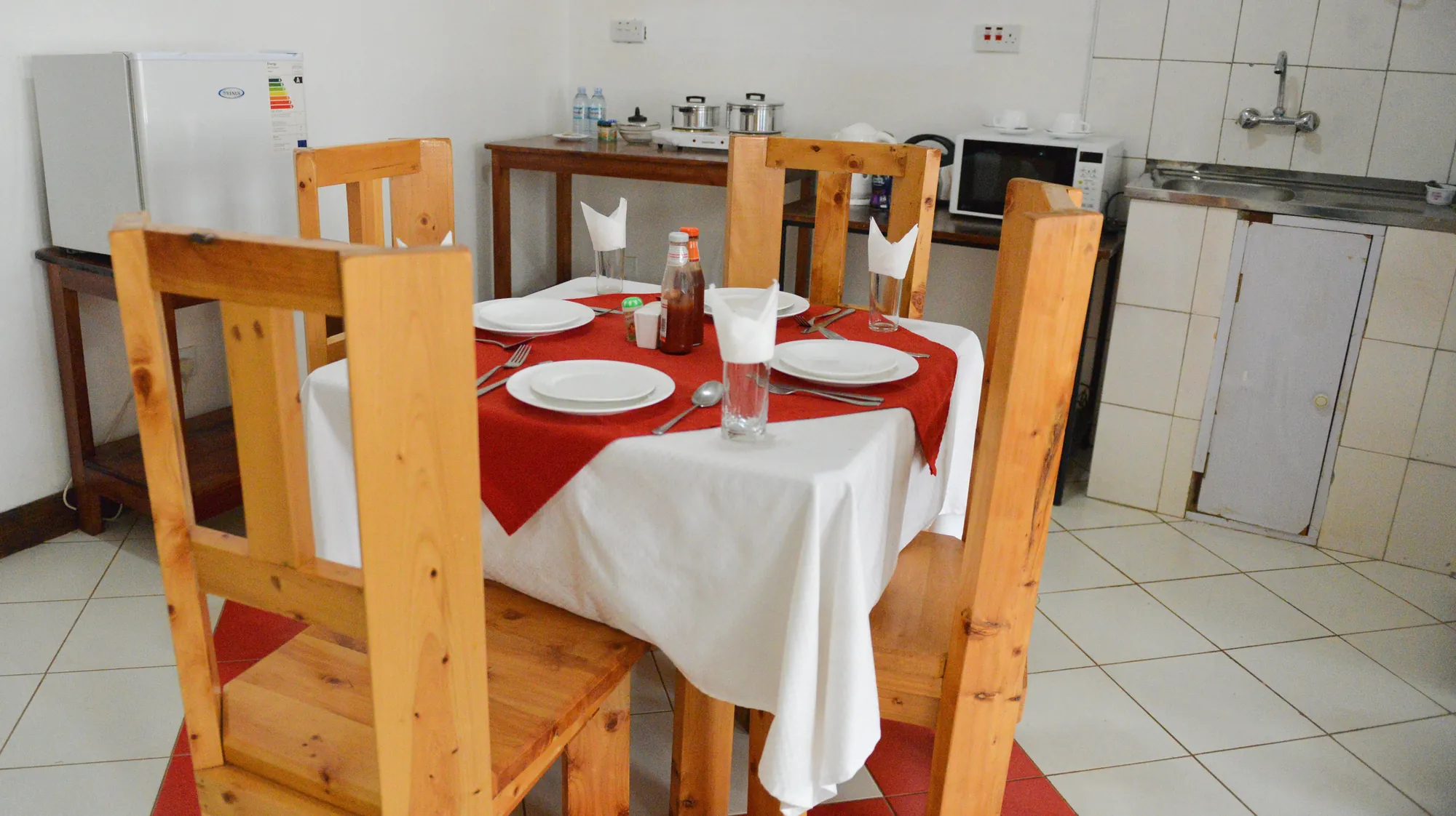 Family Suite: dining table laid for two beside the kitchenette of a self-catering suite