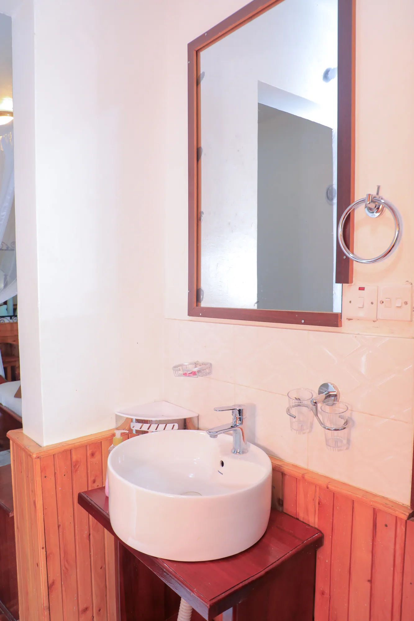 A bathroom vessel basin on a timber vanity below a mirror