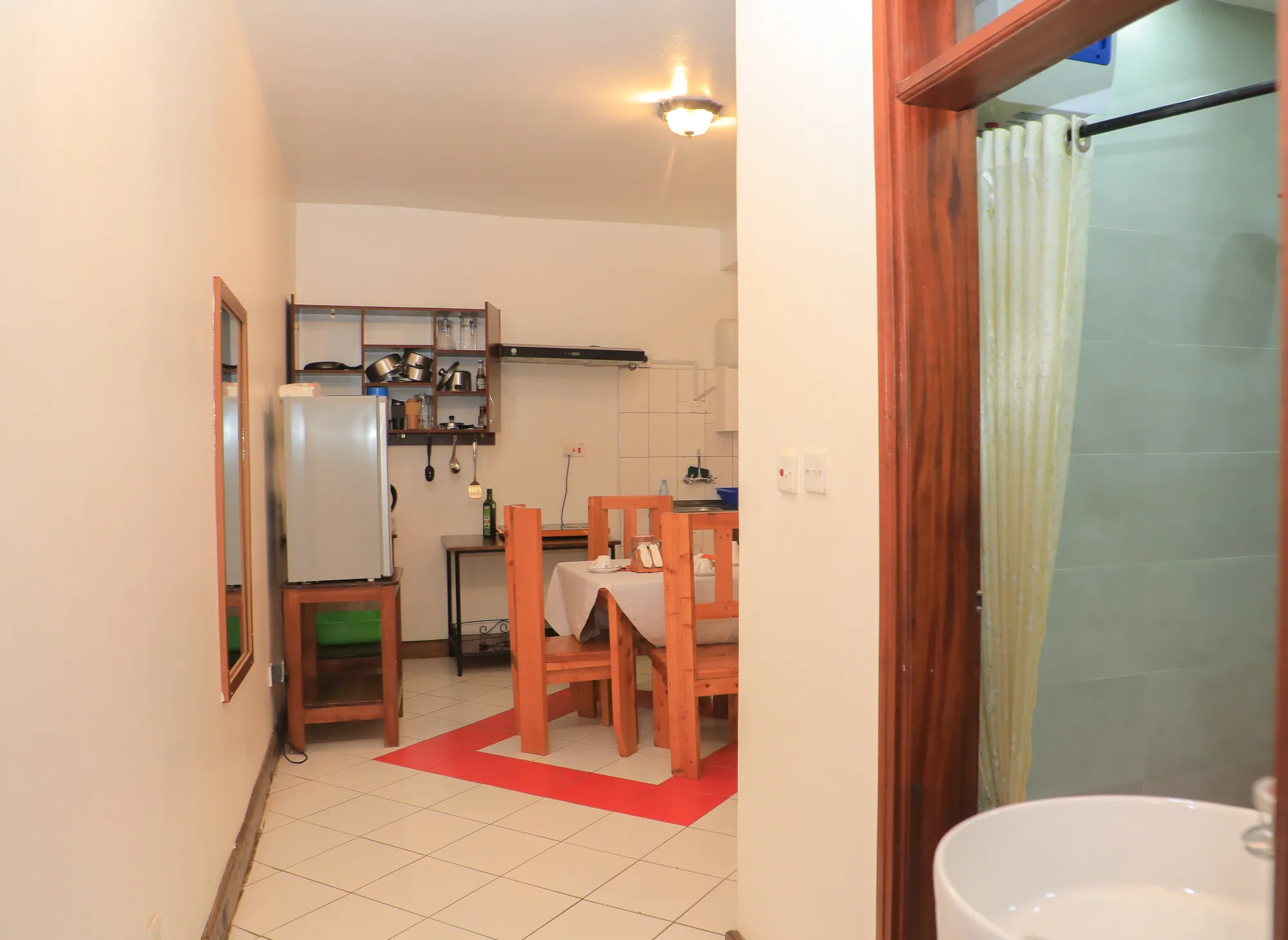 A self-catering unit's kitchen and dining area seen past the open bathroom door