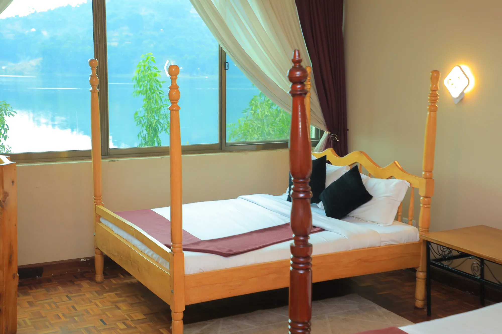 Single Room: single four-poster bed with a maroon runner in front of a lake-facing window