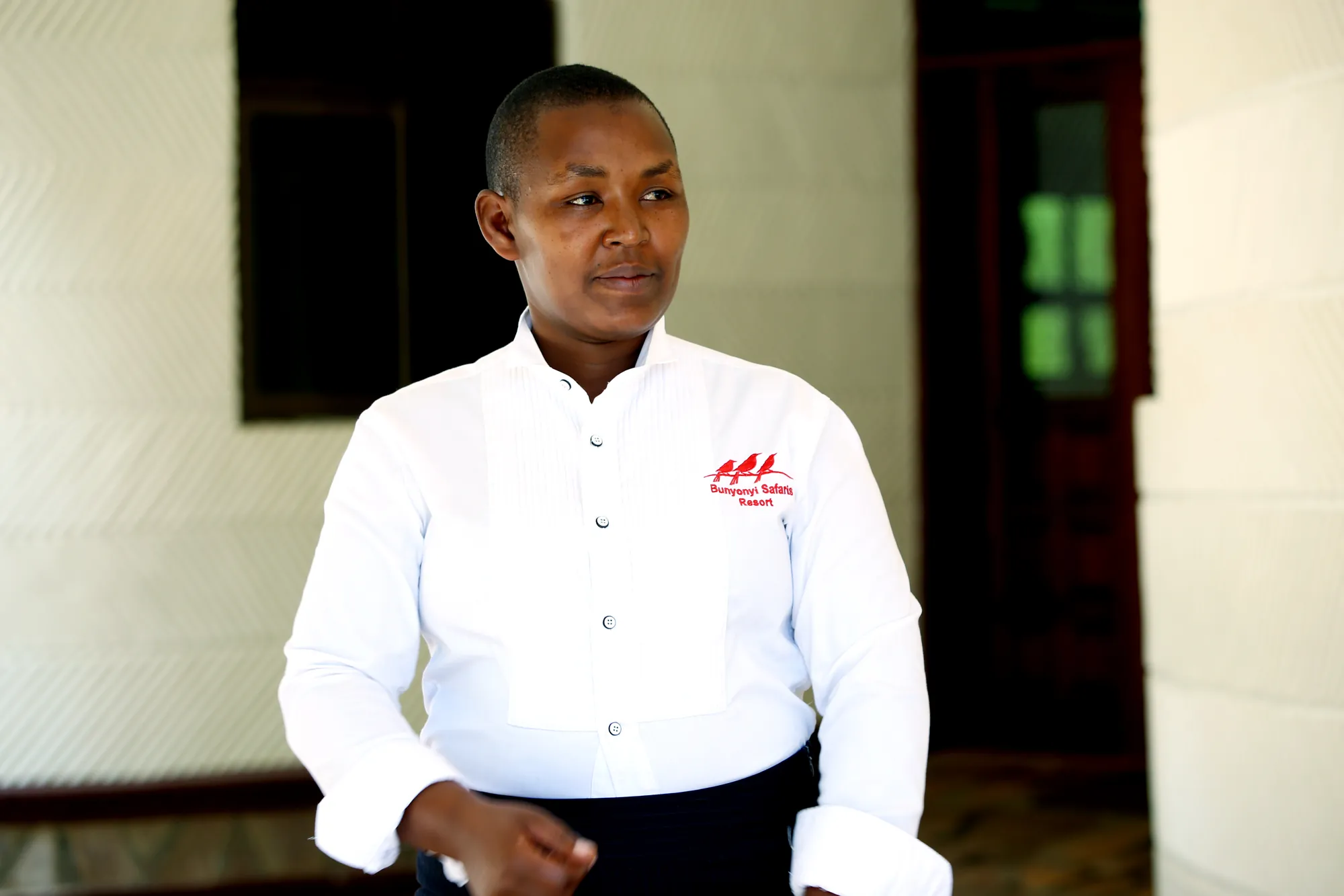 A staff member in a branded white shirt standing in the lobby