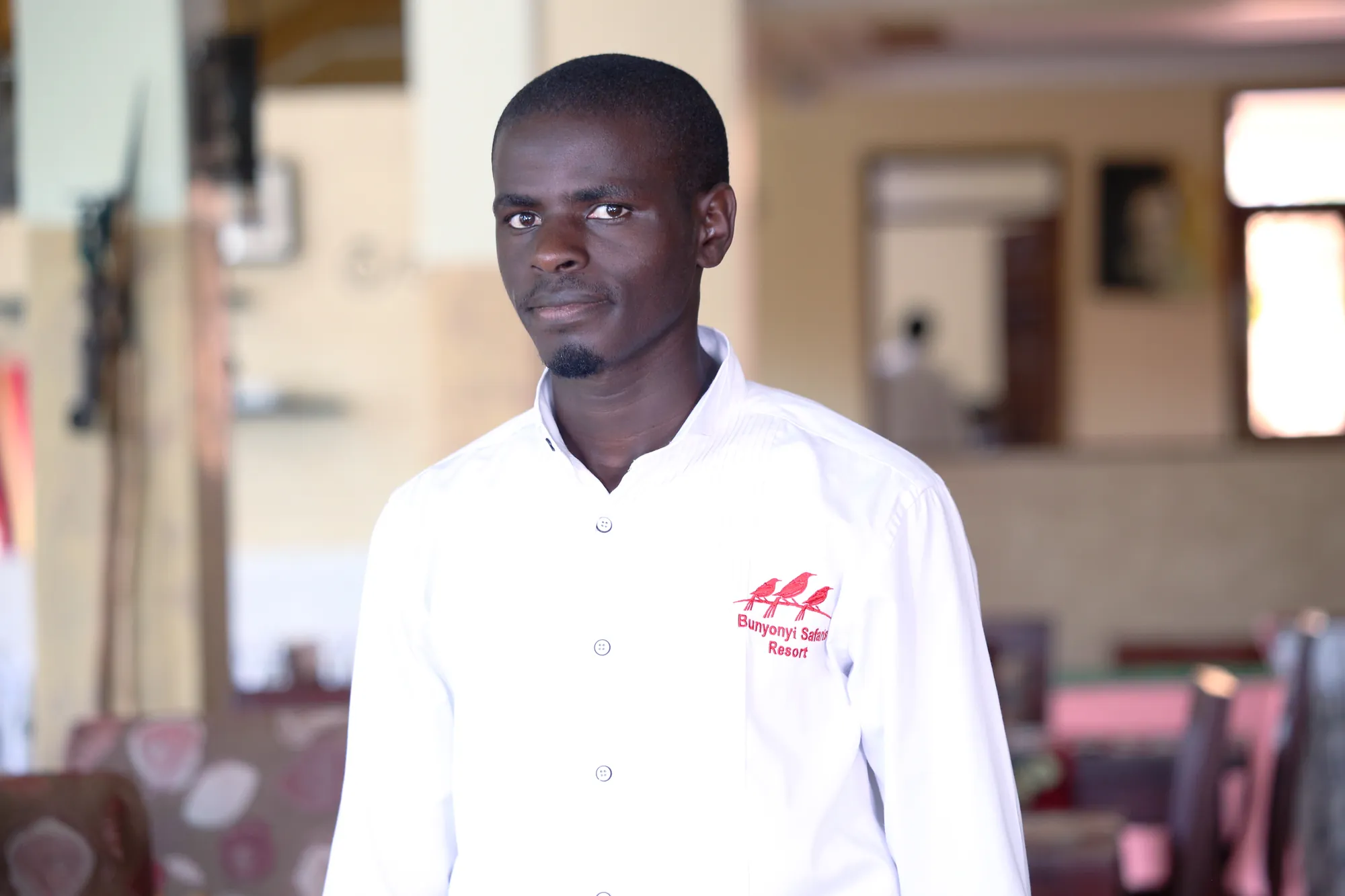 A staff member in a branded white shirt in the restaurant