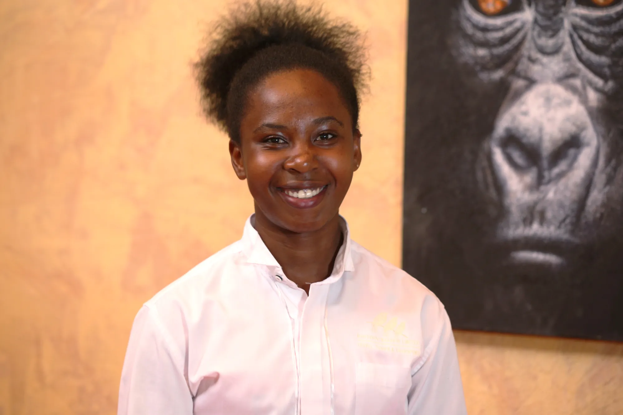 A staff member in a pale shirt in front of a framed gorilla photograph