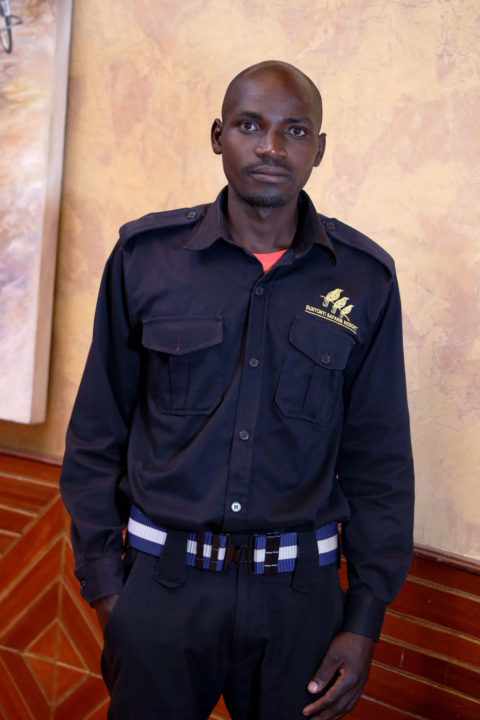A security officer in a dark uniform standing indoors