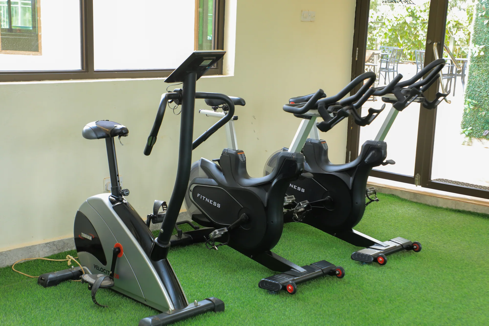 Two exercise bikes in front of the gym windows