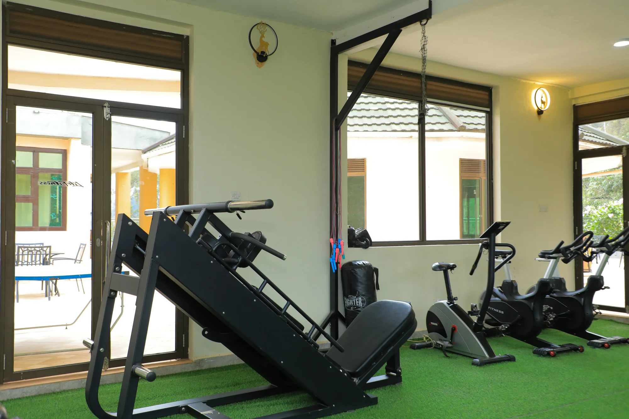 A leg press and exercise bikes beside the gym's glazed door
